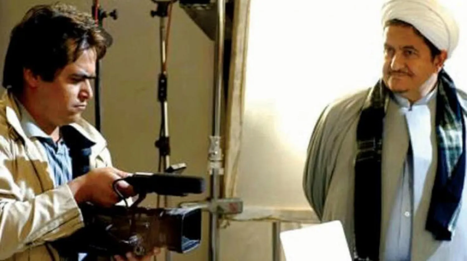 Roohollah Zam holds a camera alongside with his father Mohammad Ali Zam (Arabic website)

