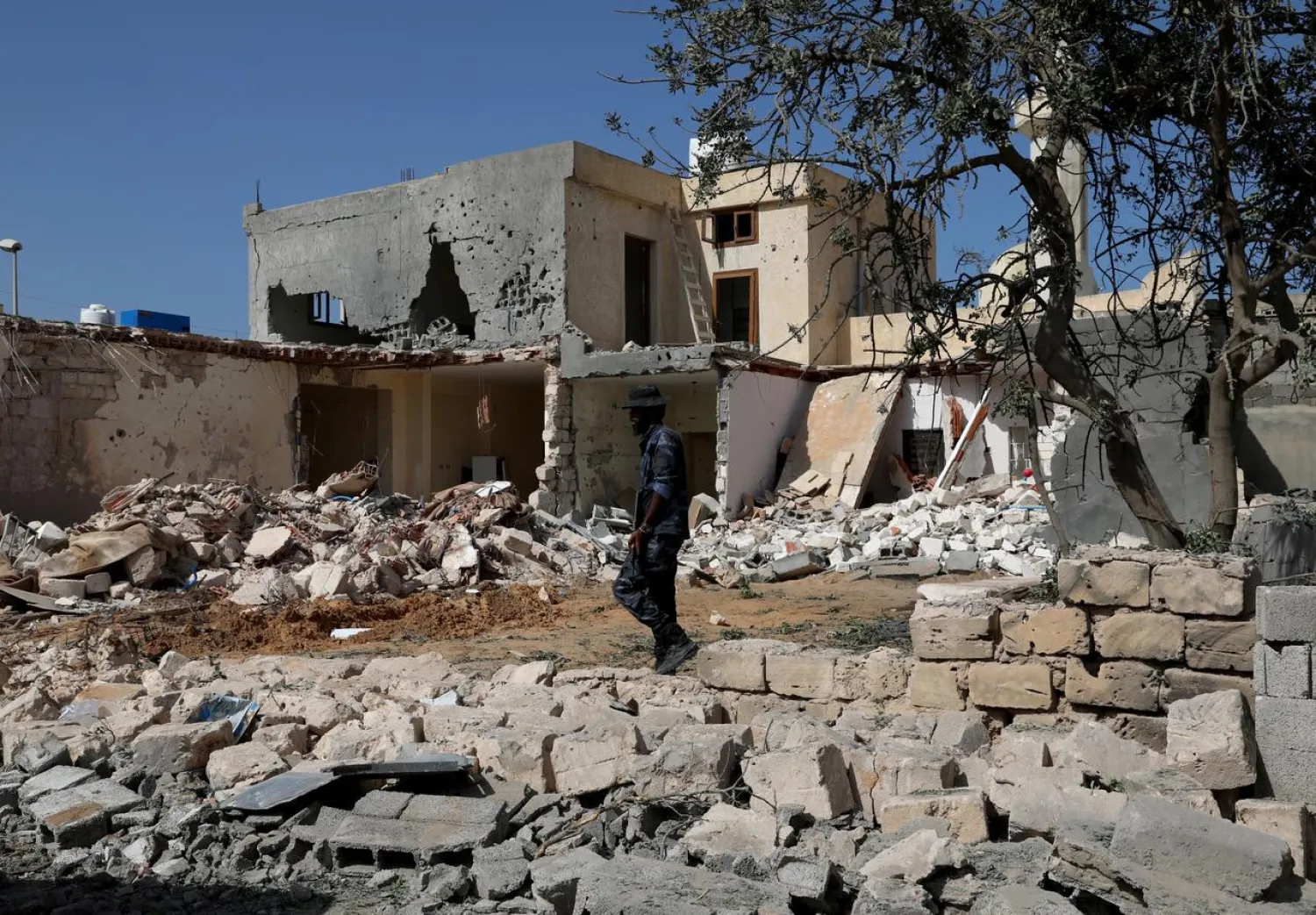 A security member inspects the site of an overnight airstrike, which hit a residential district in Tripoli, Libya October 14, 2019. (Reuters)