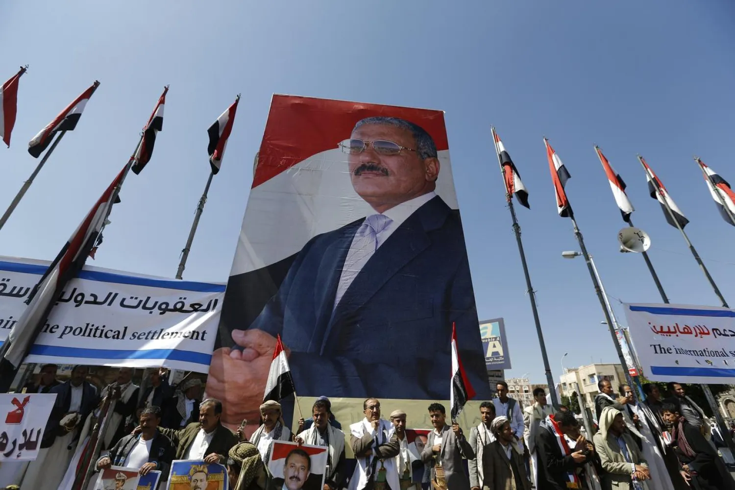 Supporters of Yemen's former President Ali Abdullah Saleh stand under a huge poster of Saleh as they rally in his support in Sanaa, Yemen November 7, 2014. (Reuters)
