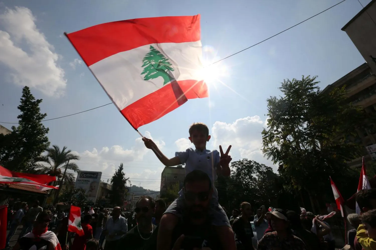 A boy holding a Lebanese flag gestures during an anti-government protest in the southern city of Nabatiyeh, Lebanon October 21, 2019. (Reuters)