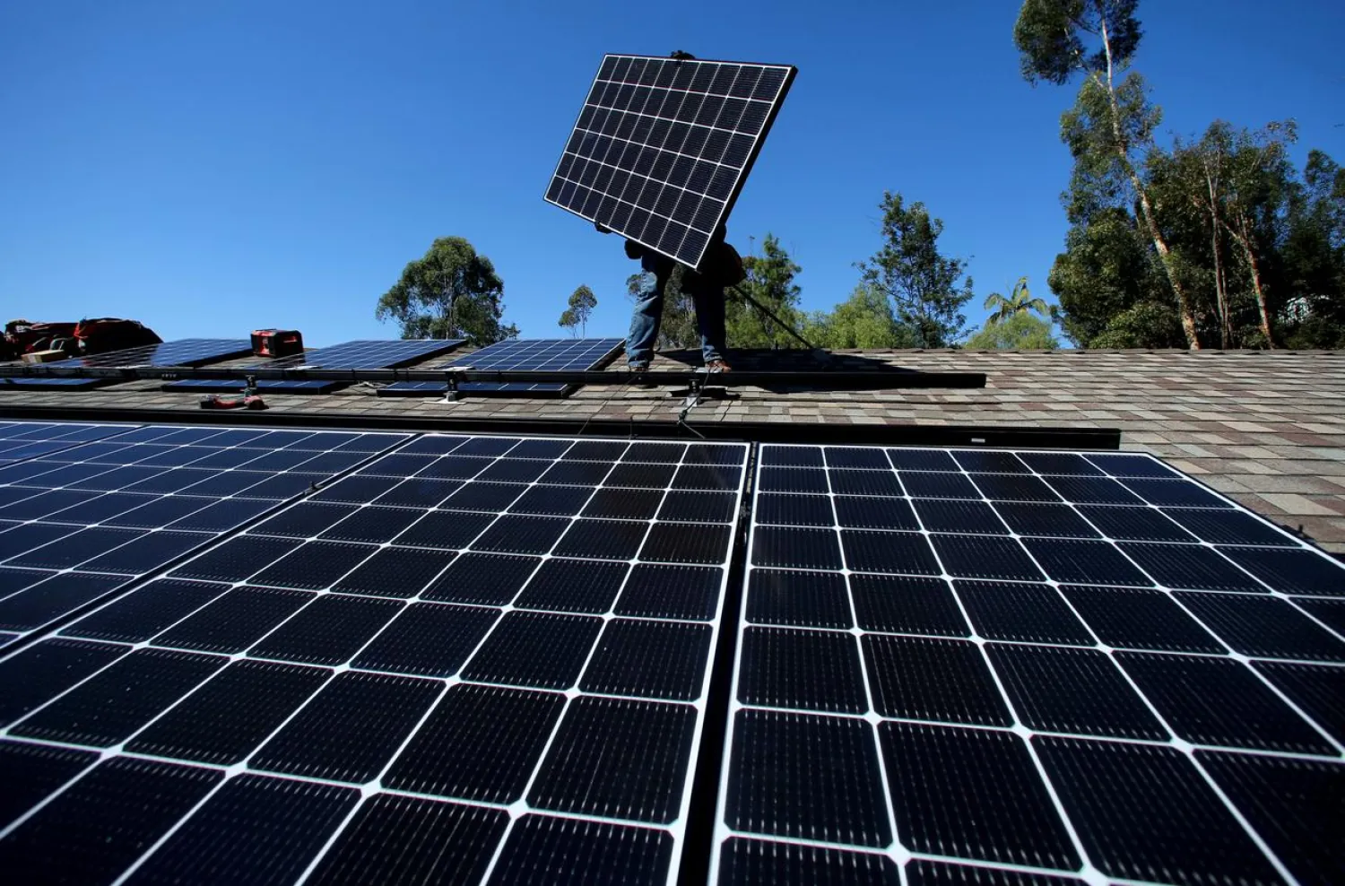 FILE PHOTO: A solar installer installs a solar panel on the roof of a residential home in Scripps Ranch, San Diego, California, US, October 14, 2016. REUTERS/Mike Blake/File Photo
