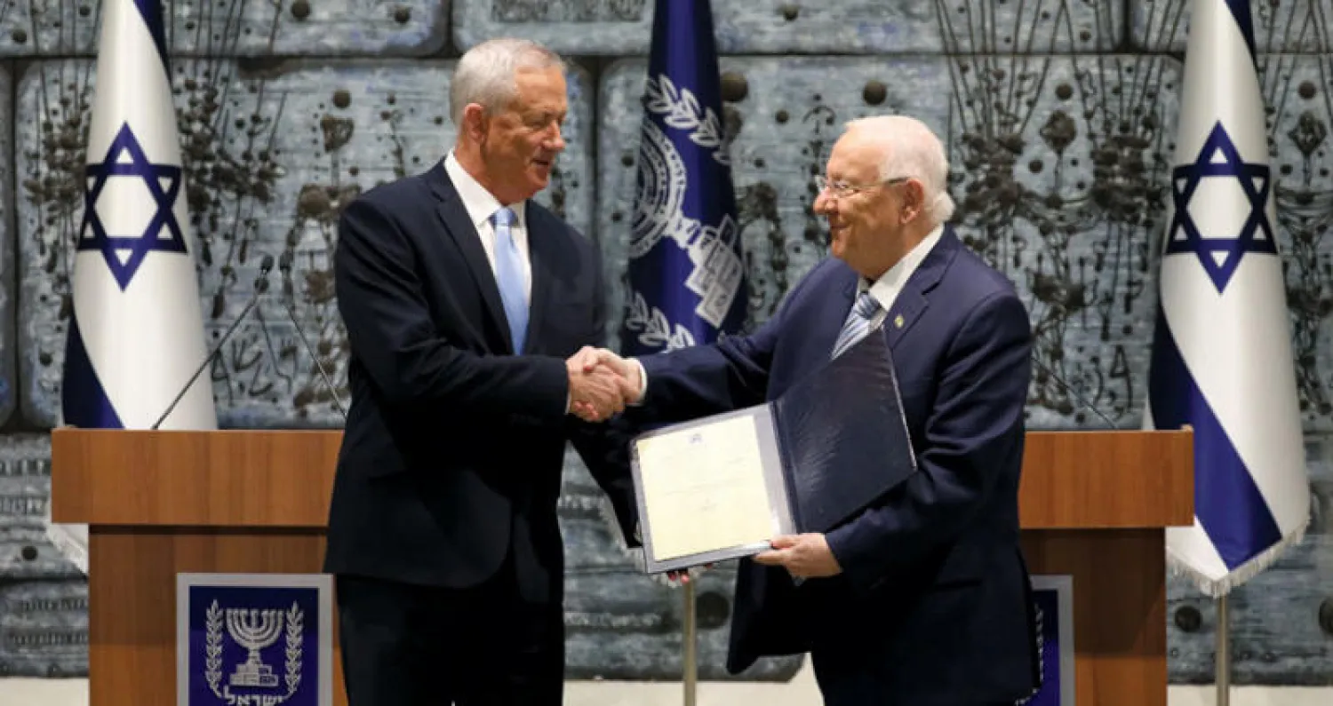 غانتس (يسار) يتسلم كتاب التكليف لتشكيل الحكومة من الرئيس الإسرائيلي رؤوفين ريفلين أمس (إ.ب.أ)