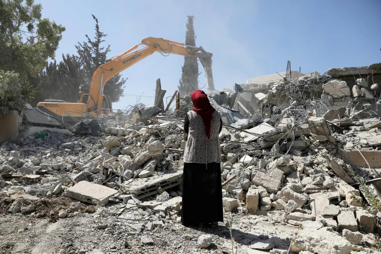 Fawzia stands on the ruins of her house, after her Palestinian ex-husband demolished the dwelling to not face the prospect of Israeli settlers moving in after he lost a land ownership case in Israeli courts, in the East Jerusalem neighborhood of Beit Hanina, July 19, 2018. REUTERS/Ammar Awad