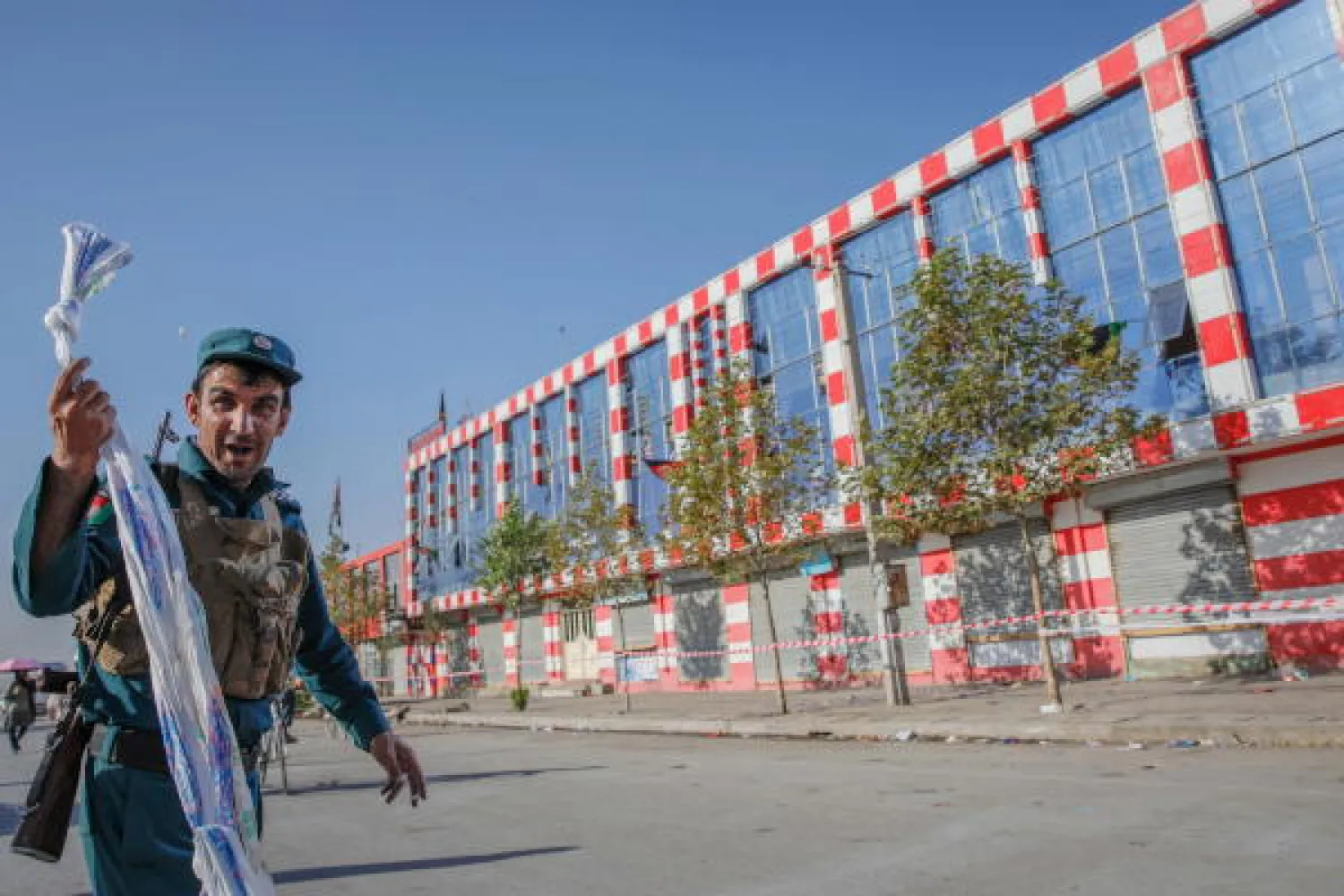 An Afghan security official stands guard outside a wedding hall that was targeted by a suicide bomber overnight, in Kabul, Afghanistan, 18 August 2019. EPA