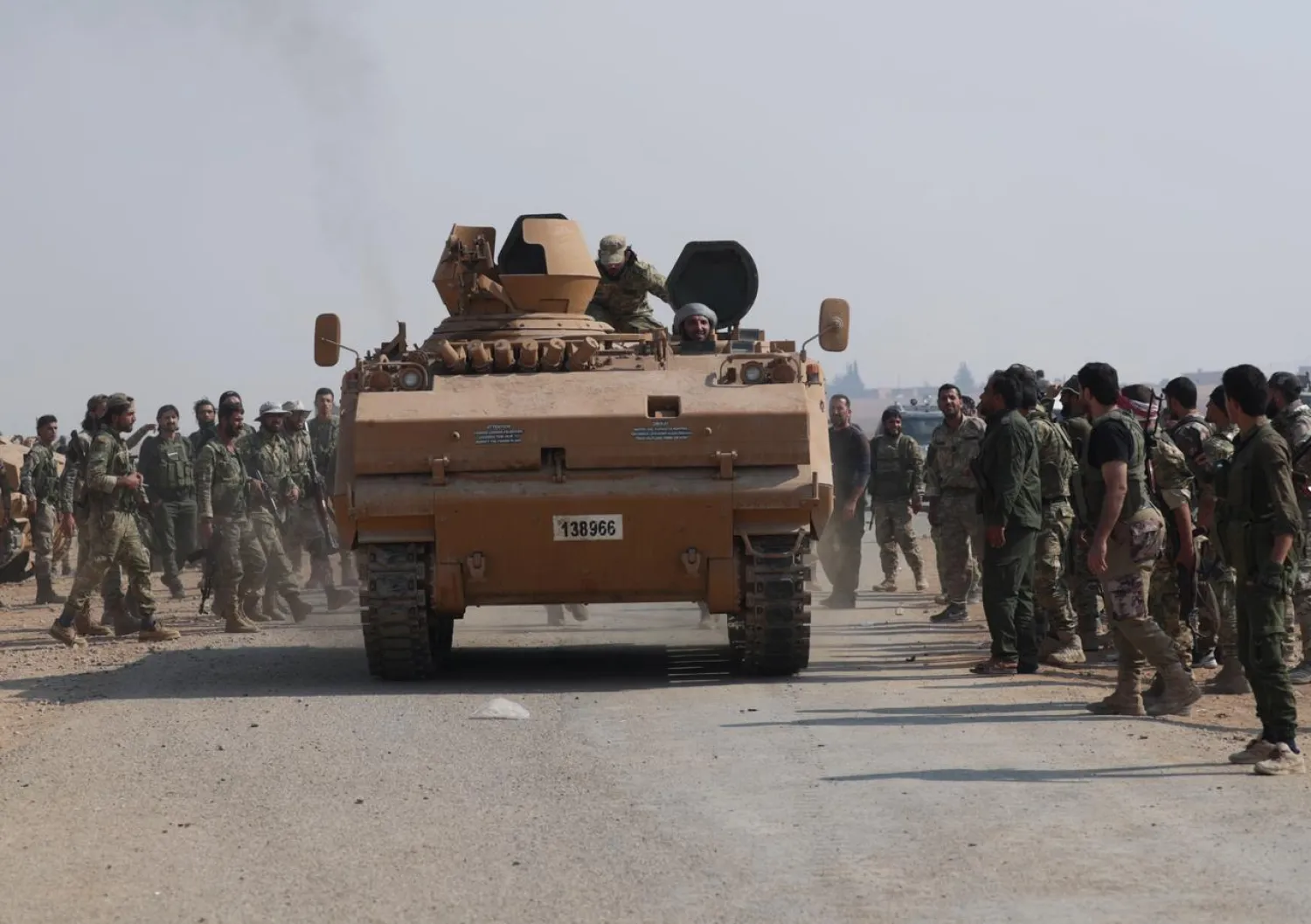 Turkey-backed Syrian rebel fighters gather as a military vehicle advances near the border town of Tal Abyad, Syria October 24, 2019. REUTERS/Khalil Ashawi