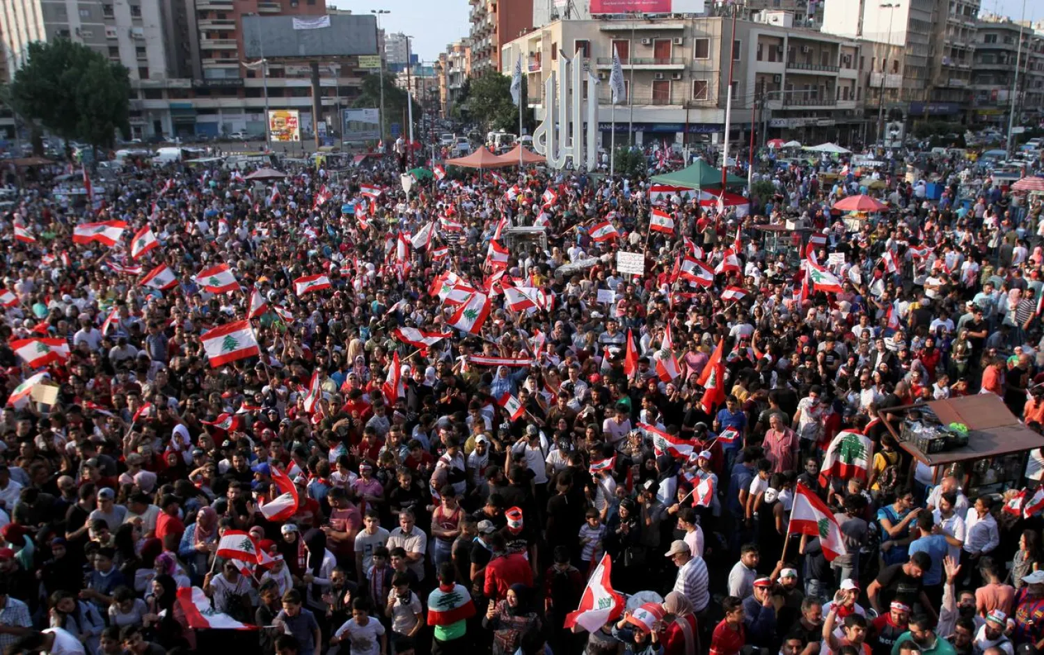 Demonstrators carry national flags during an anti-government protest in Tripoli, Lebanon October 22, 2019. REUTERS/Omar Ibrahim