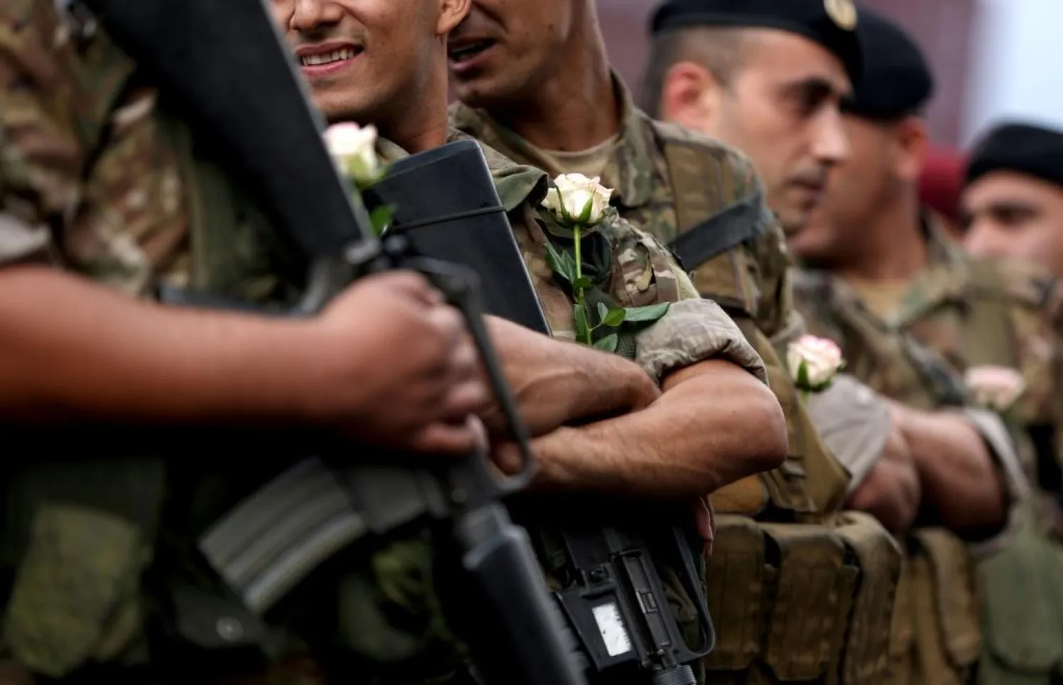 Lebanese soldiers wear white roses handed to them by protesters after they ignored pressure from the political establishment to reopen blocked roads, by force if necessary | AFP