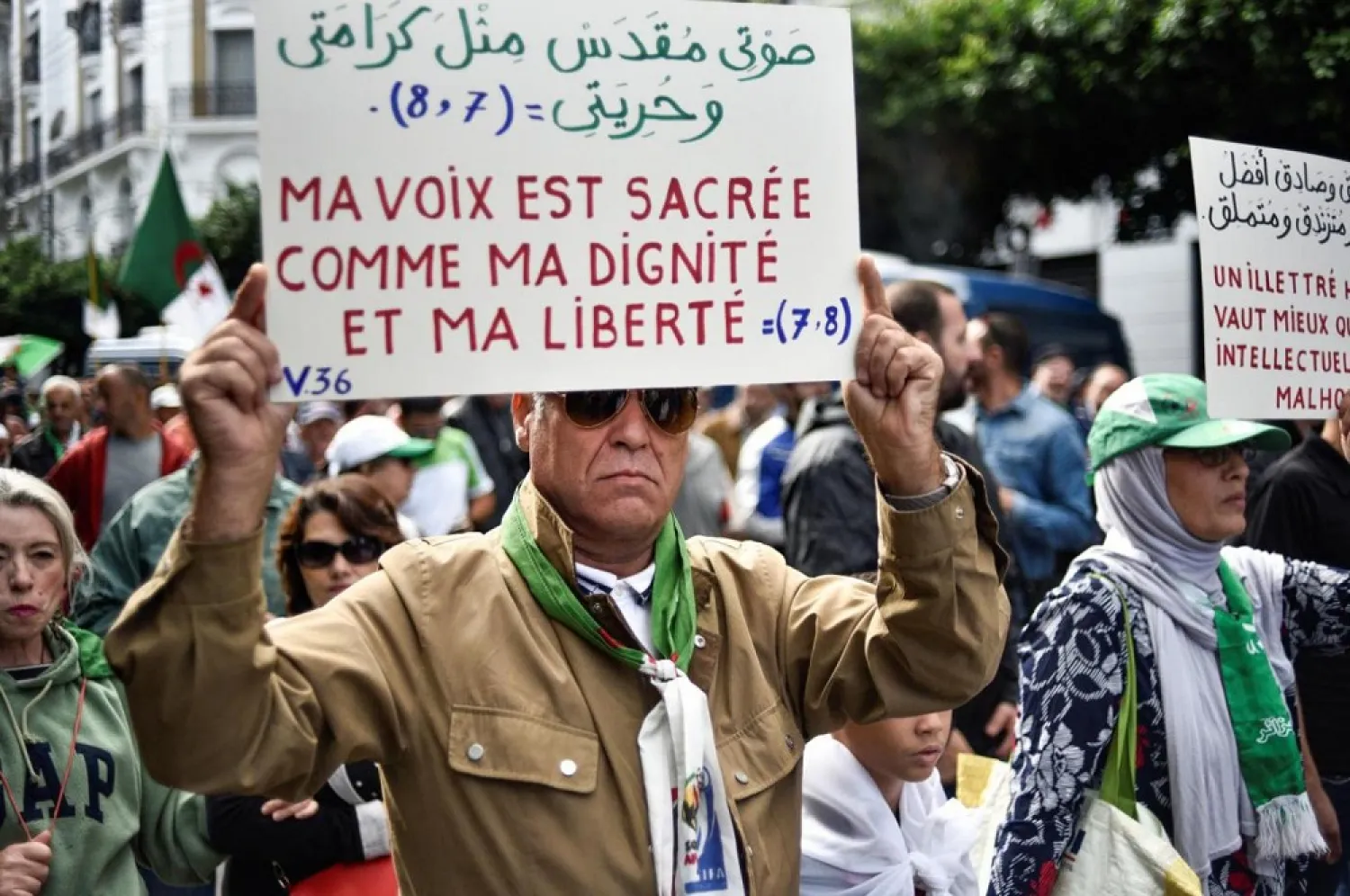 Protester in Algiers holds up sign that reads, 'My voice is sacred just like my dignity and my freedom'. (AFP)