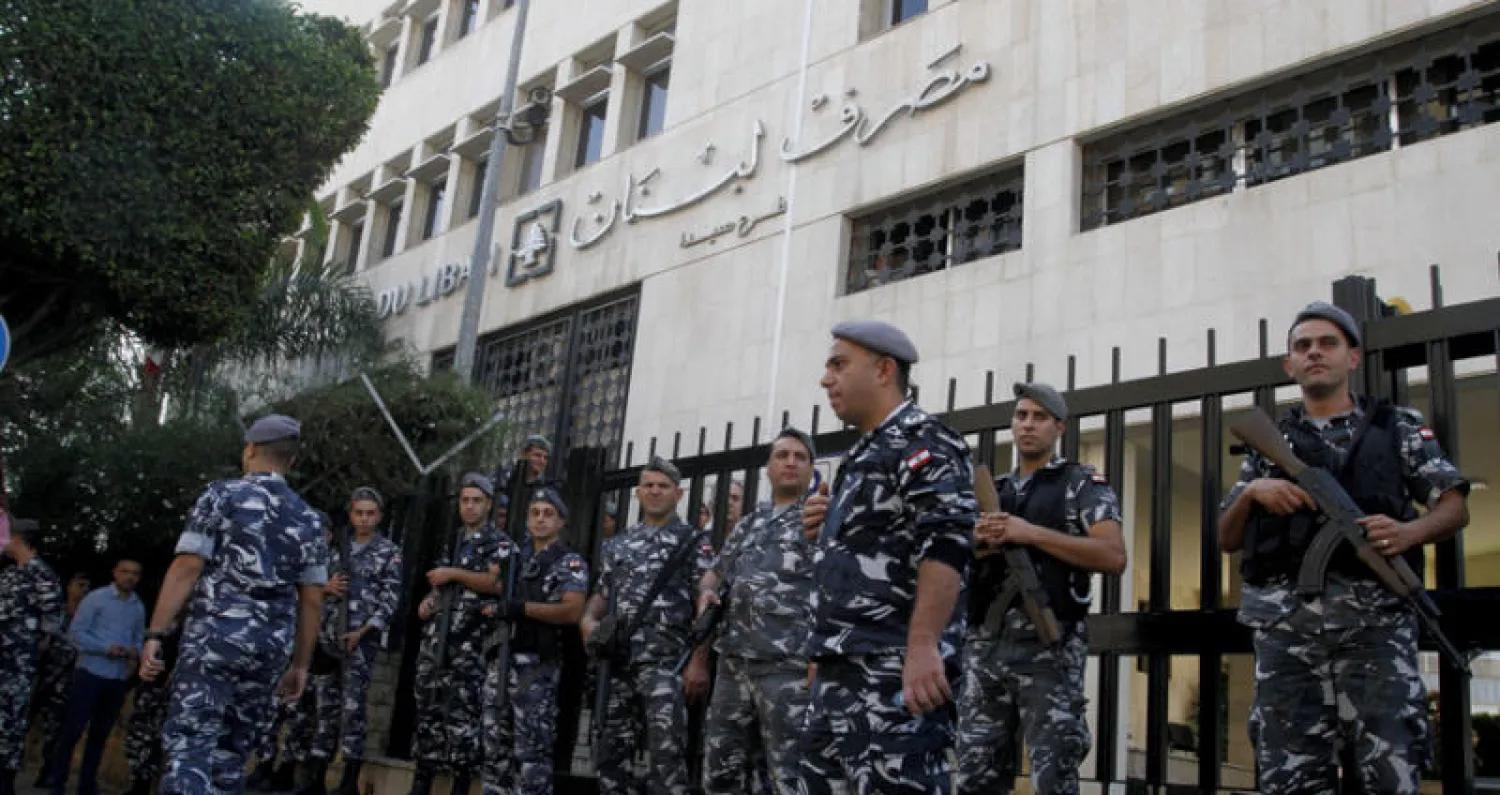 عناصر من قوى الأمن الداخلي تحيط بمقر فرع مصرف لبنان المركزي بمدينة صيدا الجنوبية أمس (أ.ف.ب)