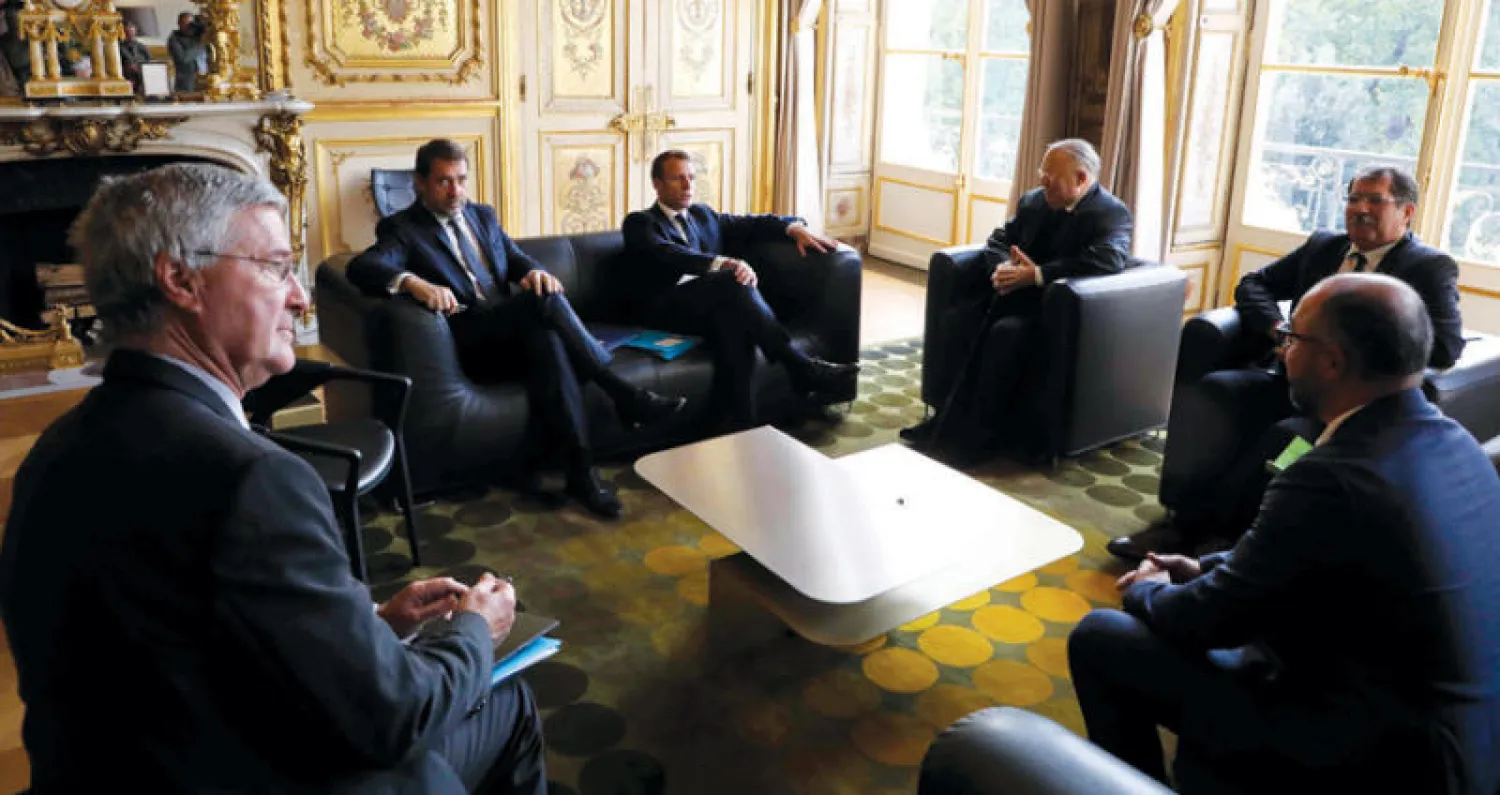 ماكرون ووزير الداخلية يجتمعان بممثلين عن مسلمي فرنسا في الإليزيه أمس (أ.ف.ب)