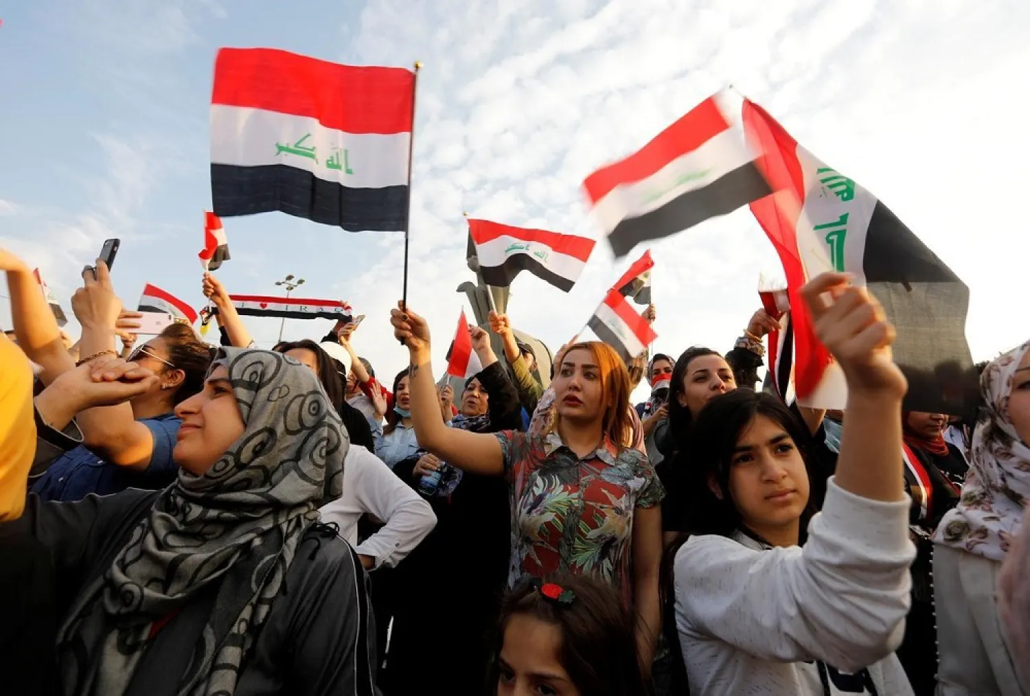 Women demonstrators hold Iraqi flags as they take part in a protest in Baghdad, Iraq October 27, 2019. (Reuters)