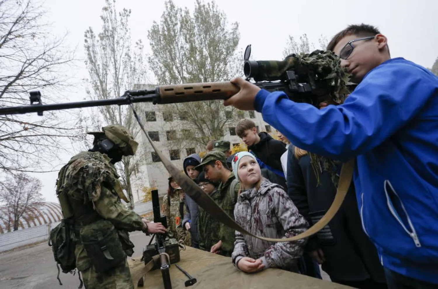 مقاتل يدرب تلامذة على استعمال السلاح في دونيتسك شرق أوكرانيا (أرشيف – إ.ب.أ)