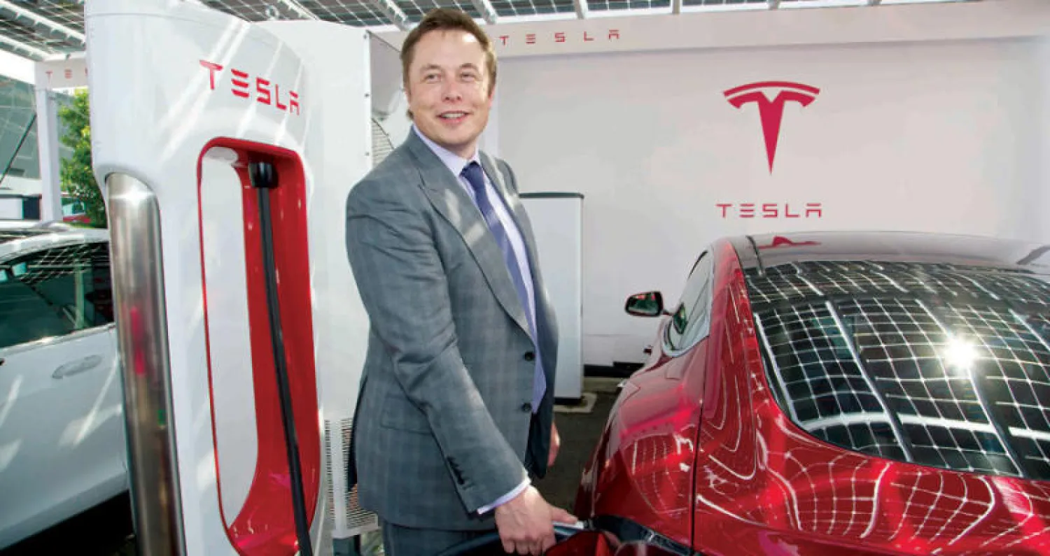 إيلون ماسك مع سيارة تيسلا