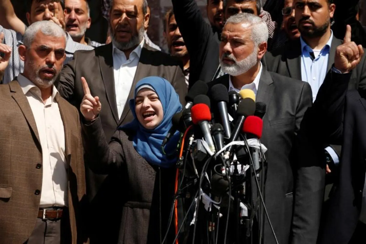 Hamas Chief Ismail Haniyeh (R) and Hamas Gaza leader Yehya Al-Sinwar (L) attend a news conference as the wife of slain senior Hamas militant Mazen Fuqaha gestures, in Gaza City May 11, 2017. REUTERS/Mohammed Salem