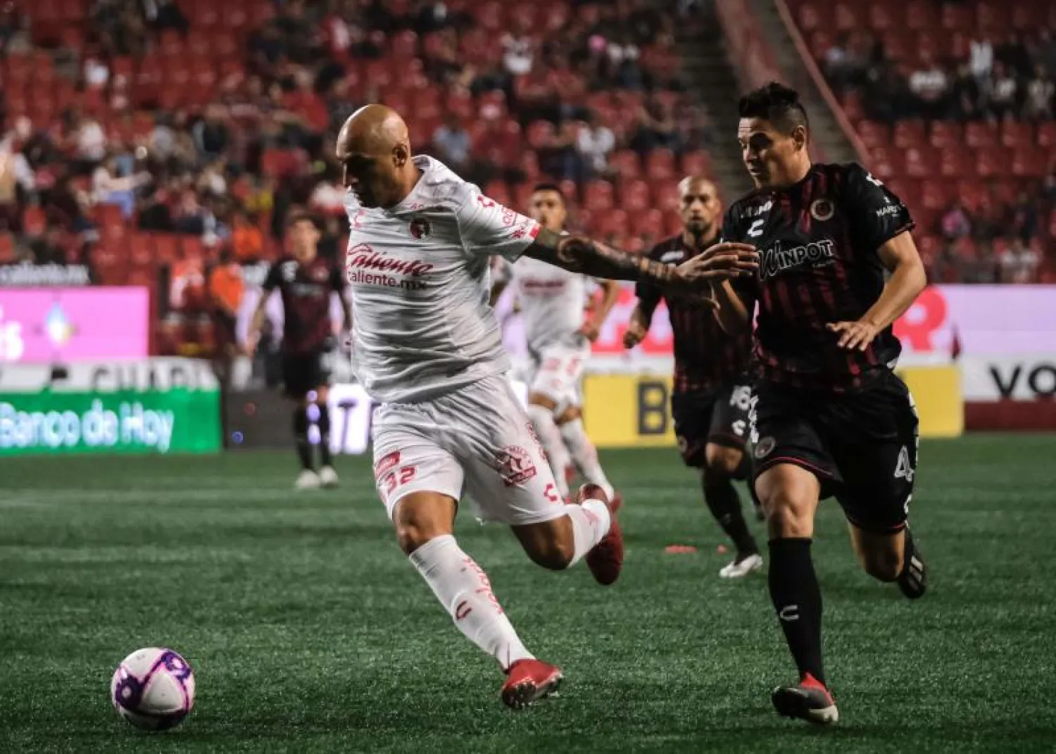 لاعبو فريق فيراكروز المكسيكي (بالأسود والأحمر) خلال إحدى المباريات في الدوري (أ.ف.ب)