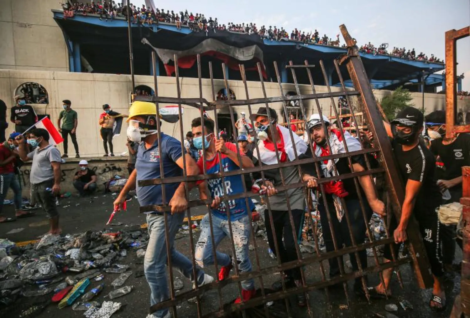   متظاهرون عراقيون خلال اشتباكات مع الشرطة في ساحة التحرير ببغداد (أ.ف.ب)