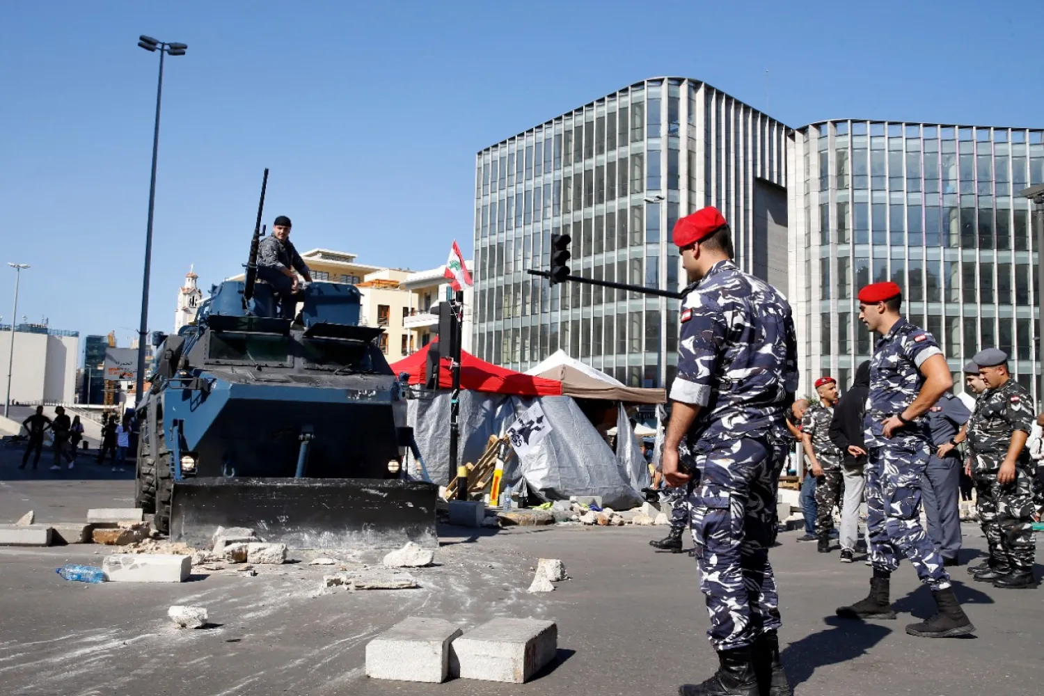 Police remove stones set up by anti-government protesters to block a main road in Beirut, Lebanon, Wednesday, Oct. 30, 2019. (AP Photo/Bilal Hussein)