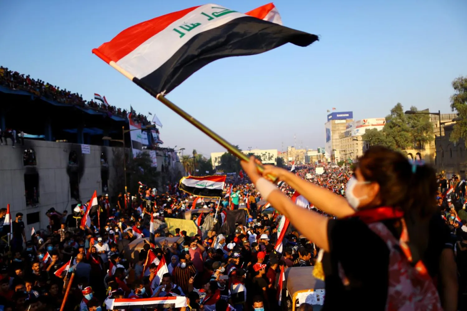 An Iraqi female demonstrator waves an Iraqi flag during an ongoing anti-government protest, in Baghdad, Iraq November 1, 2019. (Reuters)