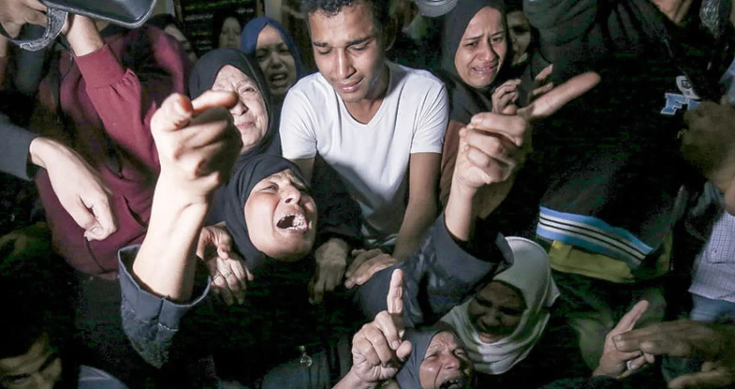 أقارب الشاب الفلسطيني أحمد الشحري الذي قتل في الغارات الإسرائيلية أمس (أ.ف.ب)