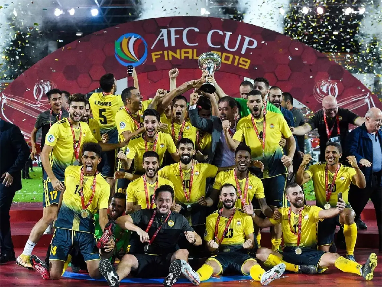 Al Ahed players and staff celebrate their win. (AFP)