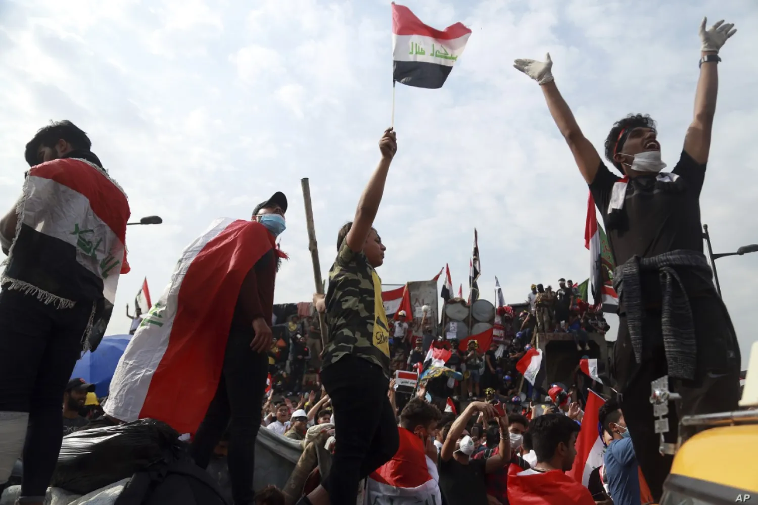 Anti-government protests stand on barriers set up by Iraqi security forces to close the Joumhouriya Bridge leading to the Green Zone government area, in Baghdad, Iraq, Nov. 3, 2019 (AP)
