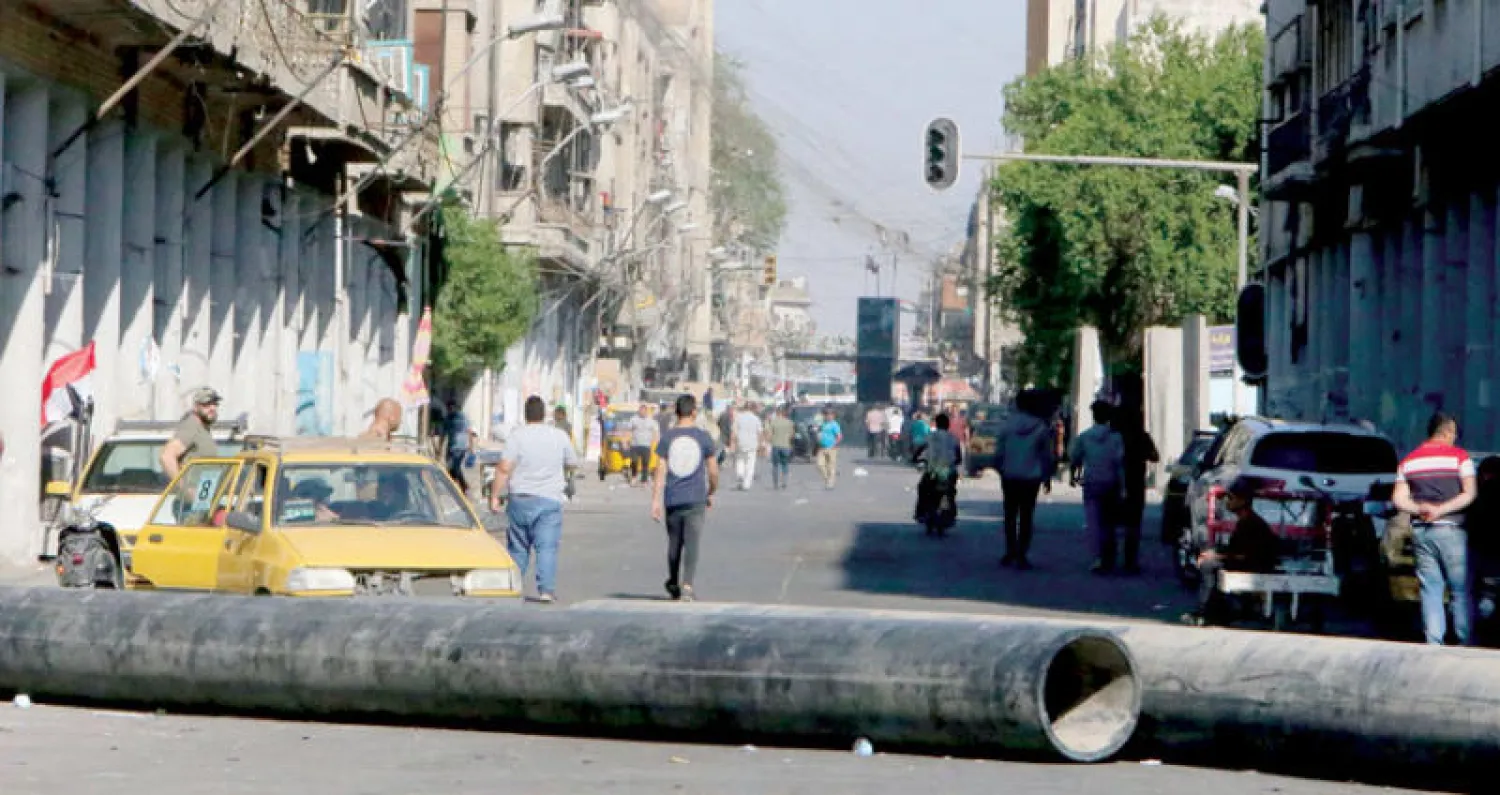 محتجون يسدون شارع الرشيد في بغداد بأنابيب أمس (أ.ف.ب)