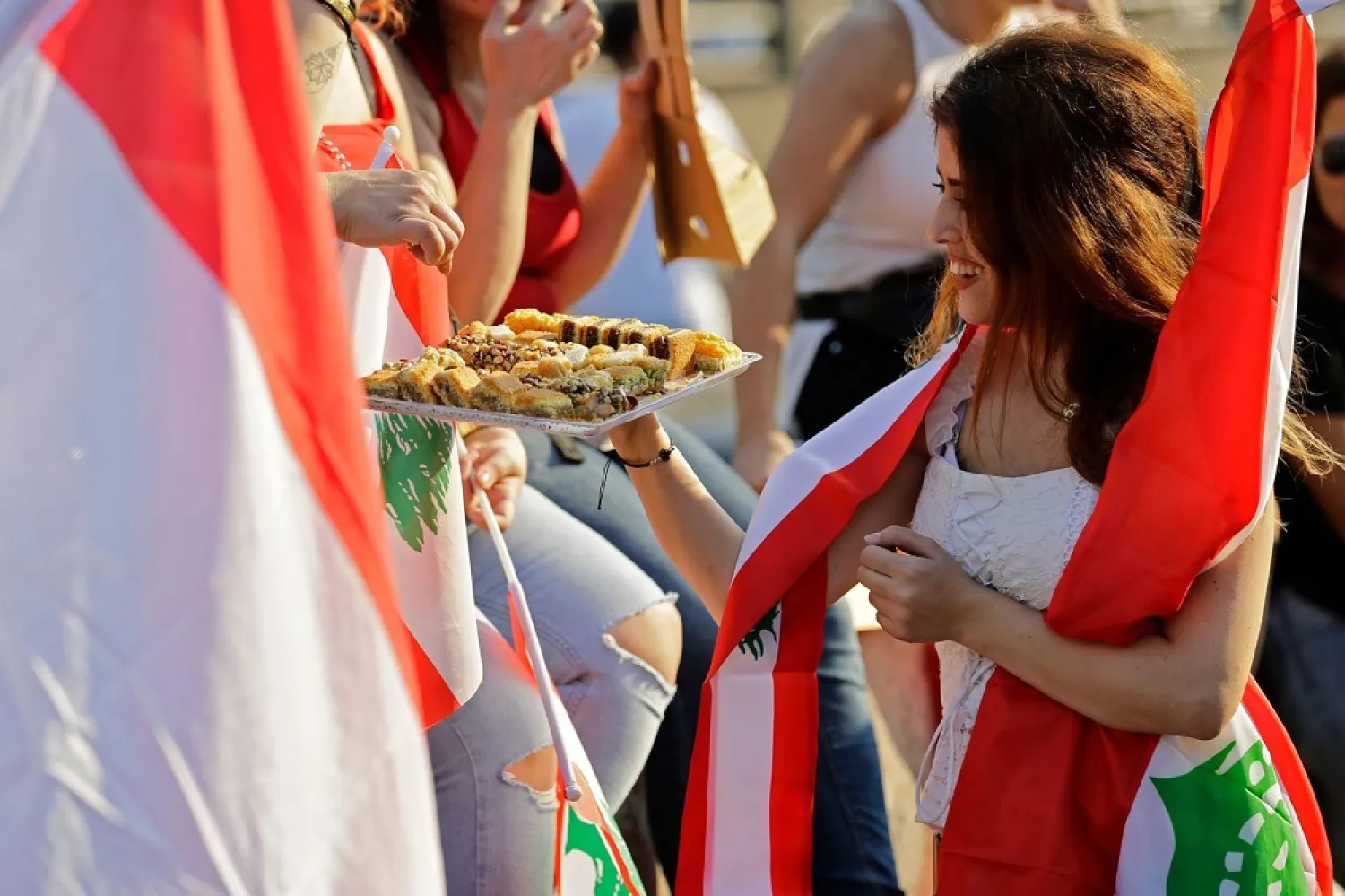 A Lebanese protester offers sweets during demonstrations in Lebanon. (Getty Images)