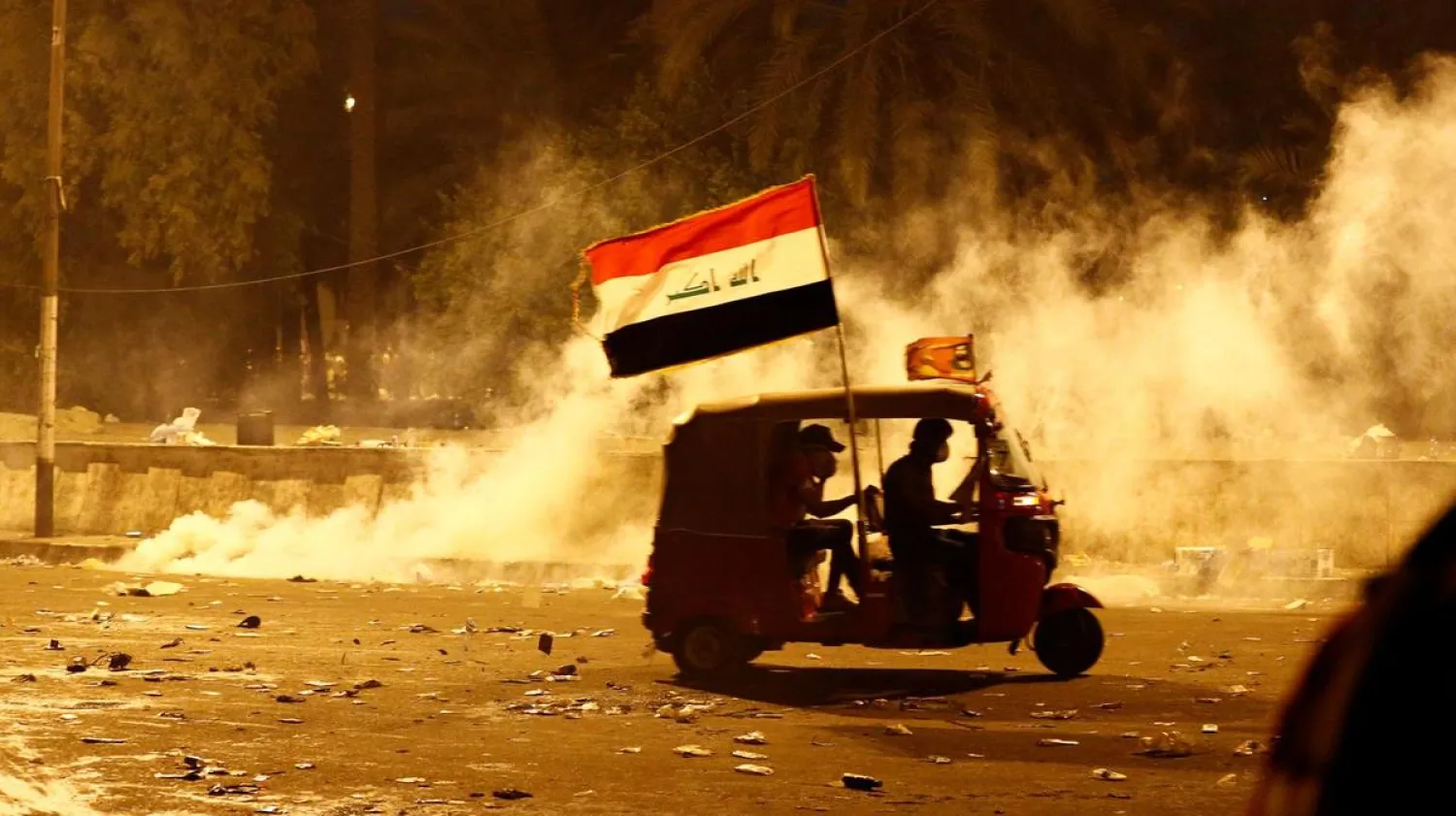 A tuk-tuk drives away from tear gas fired by Iraqi security forces during anti-government protests in Baghdad on October 26, 2019. (Reuters)