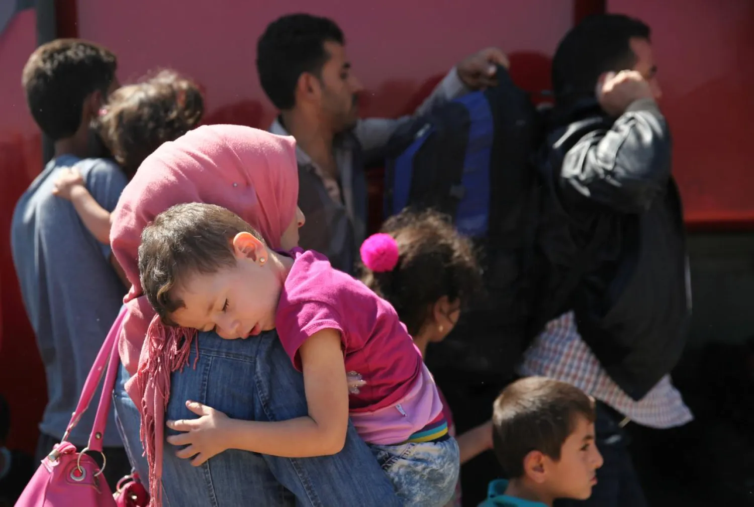 A woman holds her child outside the Kokkinotrimithia refugee camp outside Nicosia, Cyprus September 10, 2017. (Reuters)
