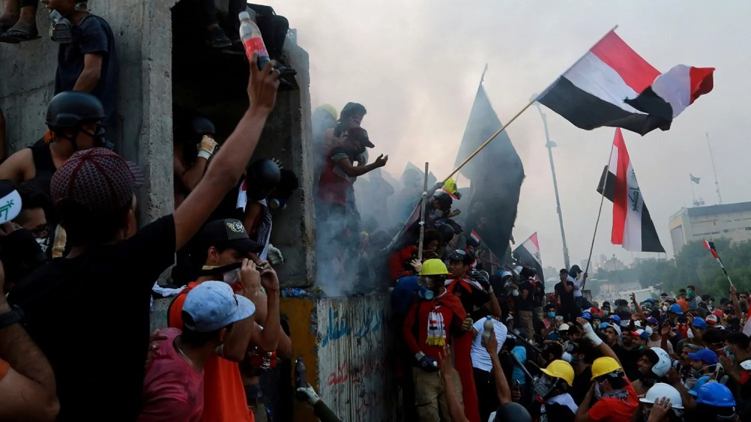 Anti-government protesters control the barriers while Iraqi security forces fire tear gas and close the bridge leading to the Green Zone, during a demonstration in Baghdad, Iraq, Oct. 29, 2019. (AP)