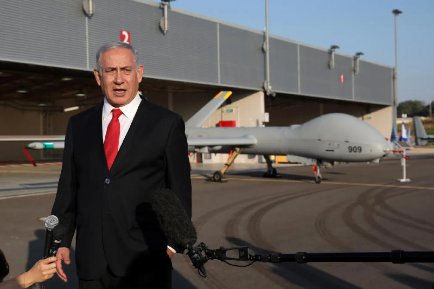 نتنياهو يتحدث إلى وسائل الإعلام خلال معرض لسلاح الجو الإسرائيلي الشهر الماضي (رويترز)