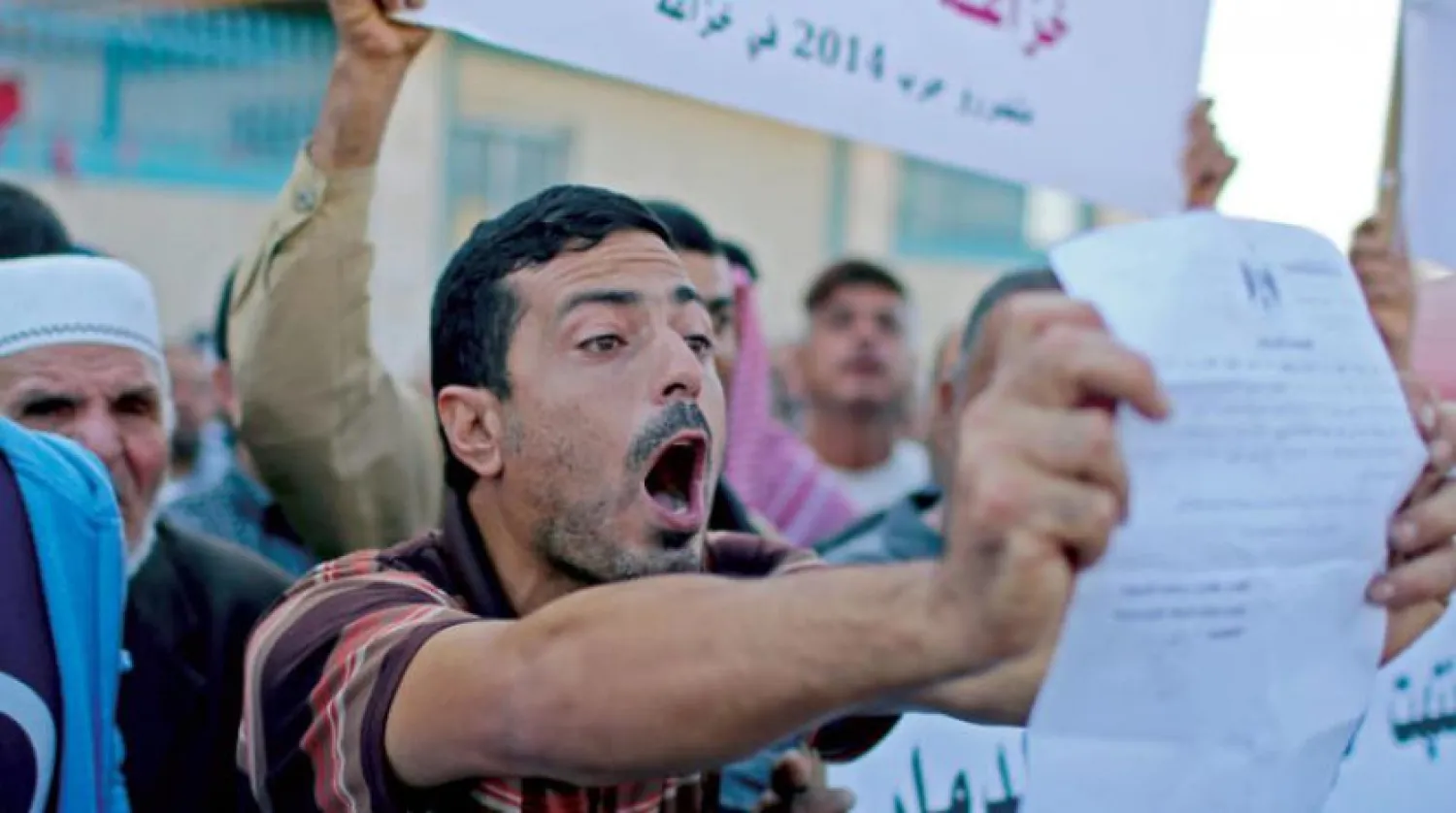 Gazze'nin güneyindeki protestocular dün UNRWA'ya 2014'te İsrail bombardımanında yıkılan evlerini inşa etmesi çağrısında bulundular (Reuters)