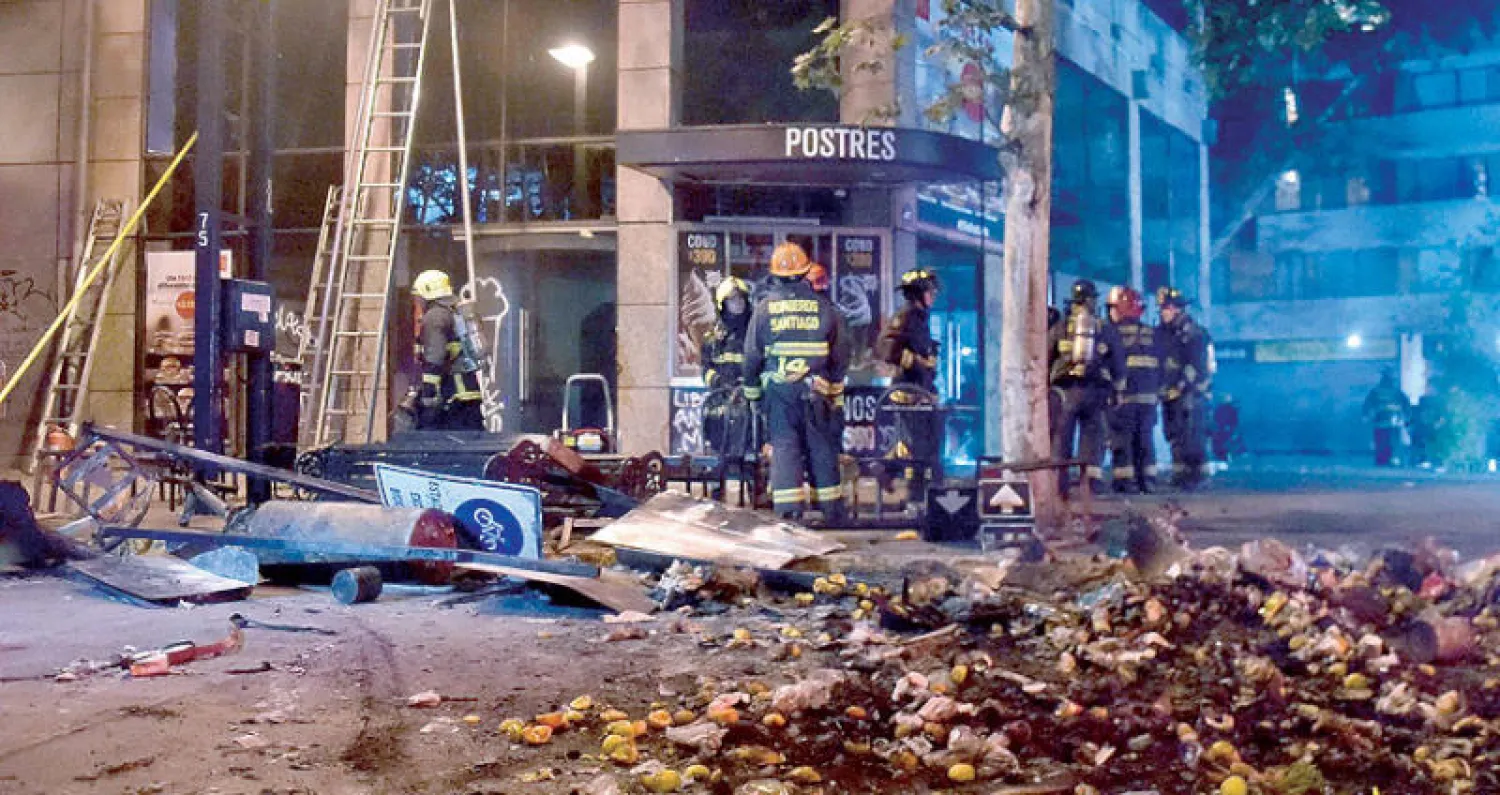 آثار حريق أشعله متظاهرون في مطعم بسنتياغو أمس (أ.ف.ب)