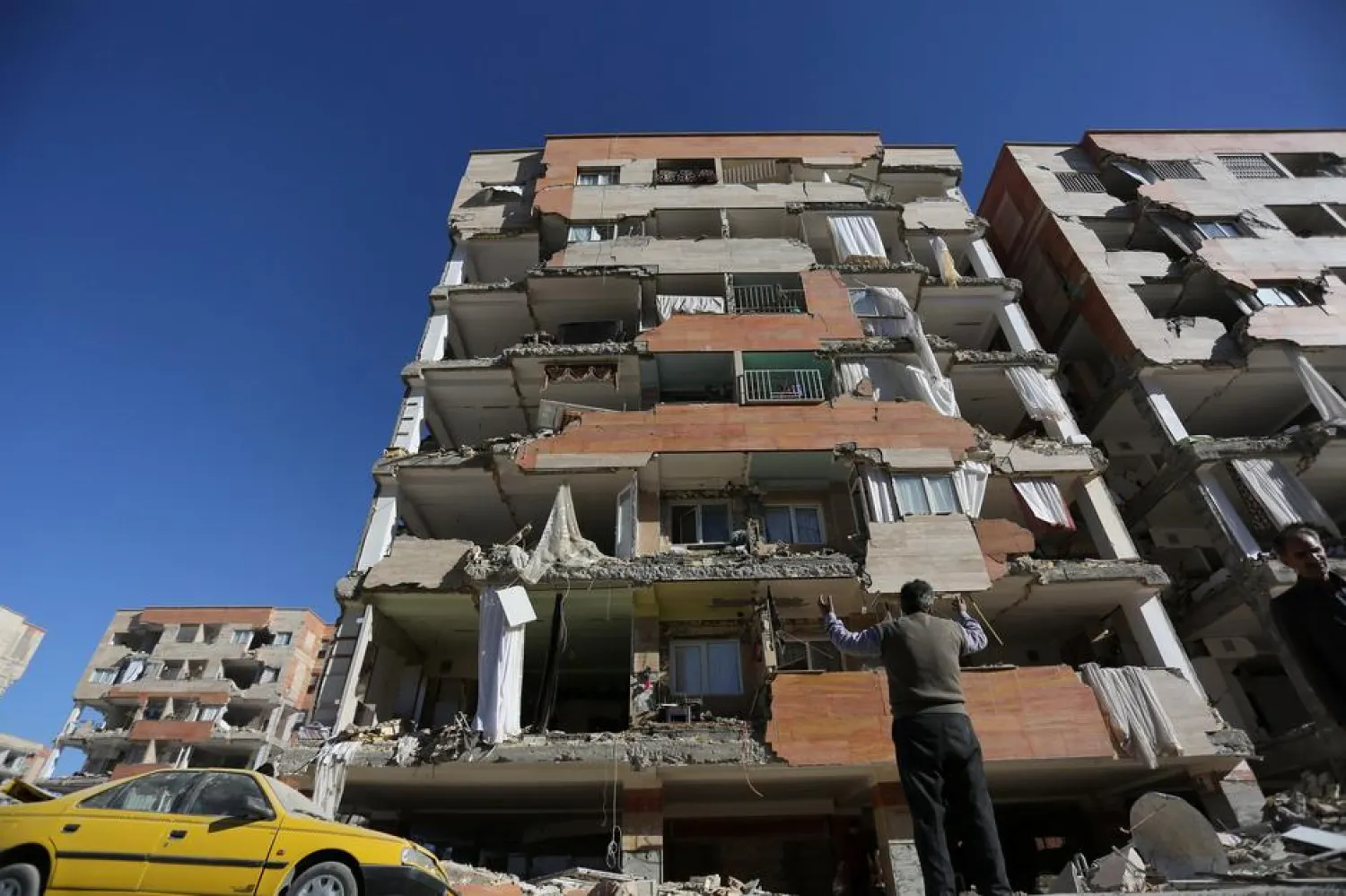 FILE: A man reacts as he looks at a damaged building in Sarpol-e Zahab county in Kermanshah, Iran. REUTERS/Tasnim News Agency
