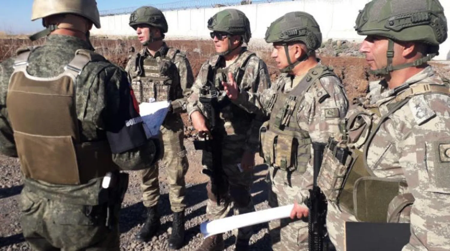Turkish officers talk with Russian officer near Turkish-Syrian border - AP
