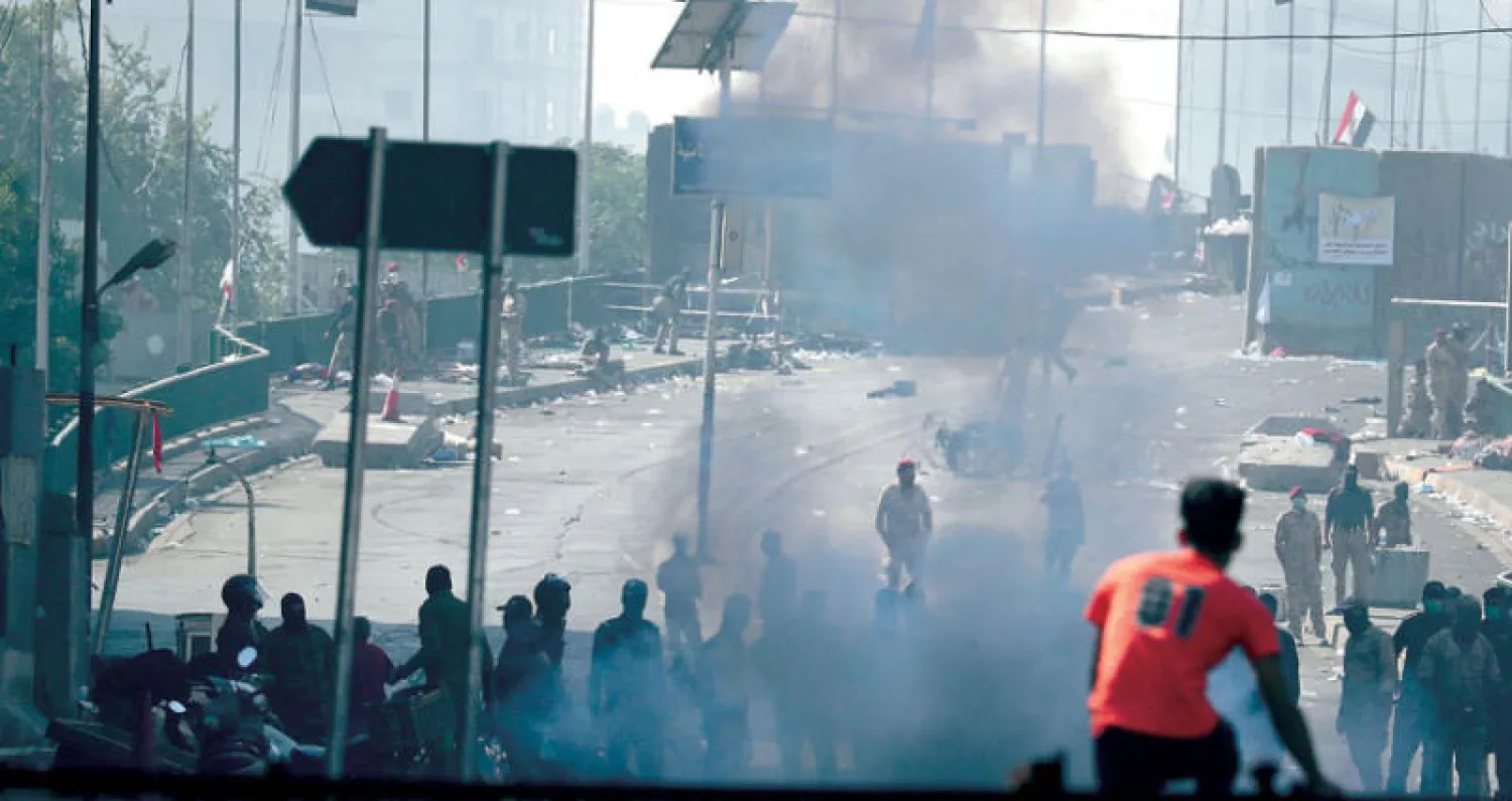 قوات مكافحة الشغب تستخدم قنابل الغاز لتفريق محتجين على أحد جسور بغداد أمس (أ.ب)