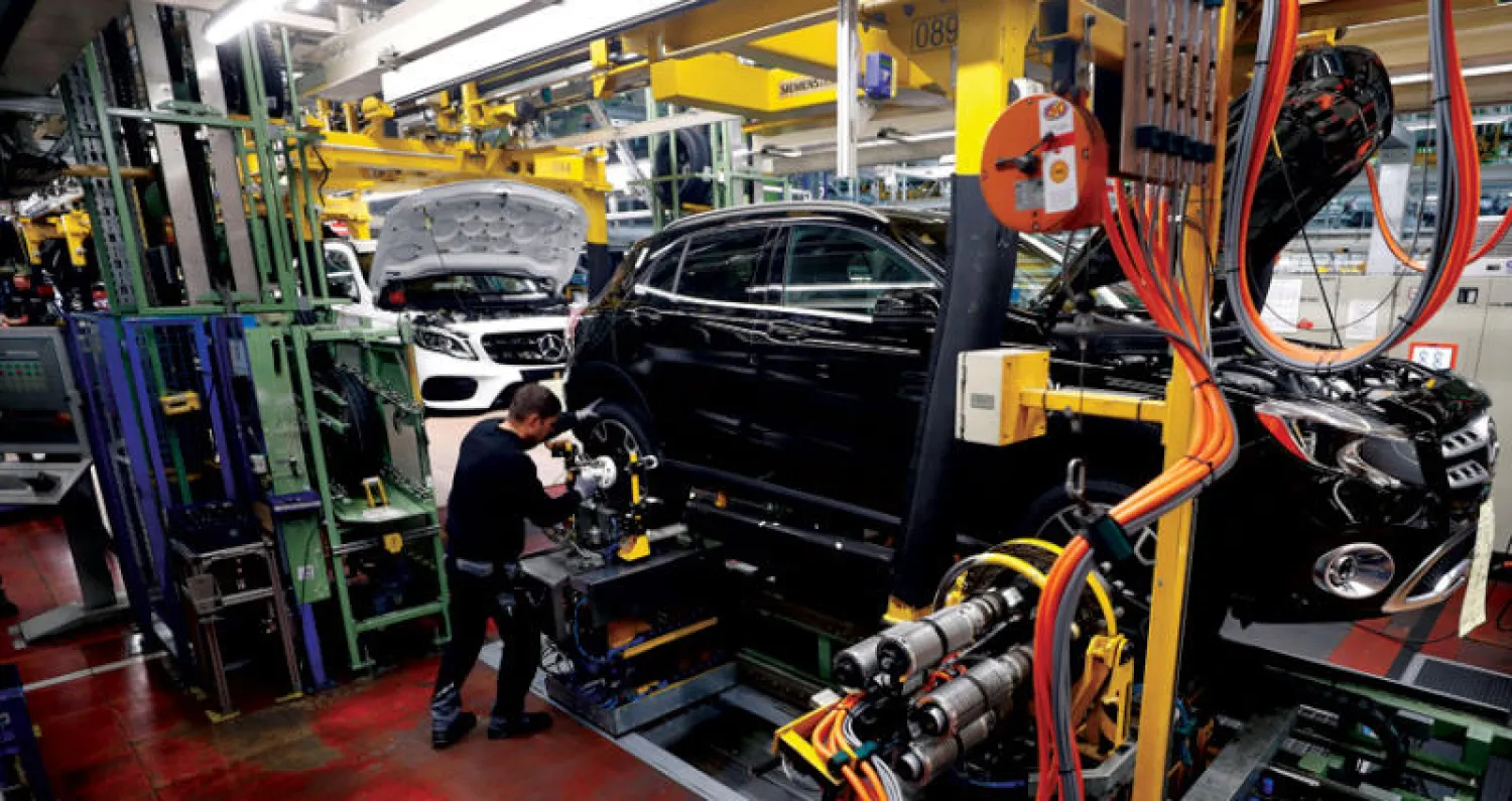 عامل في شركة صناعة السيارات الألمانية مرسيدس بنز بركب عجلات في مصنع دايملر في ألمانيا (رويترز)