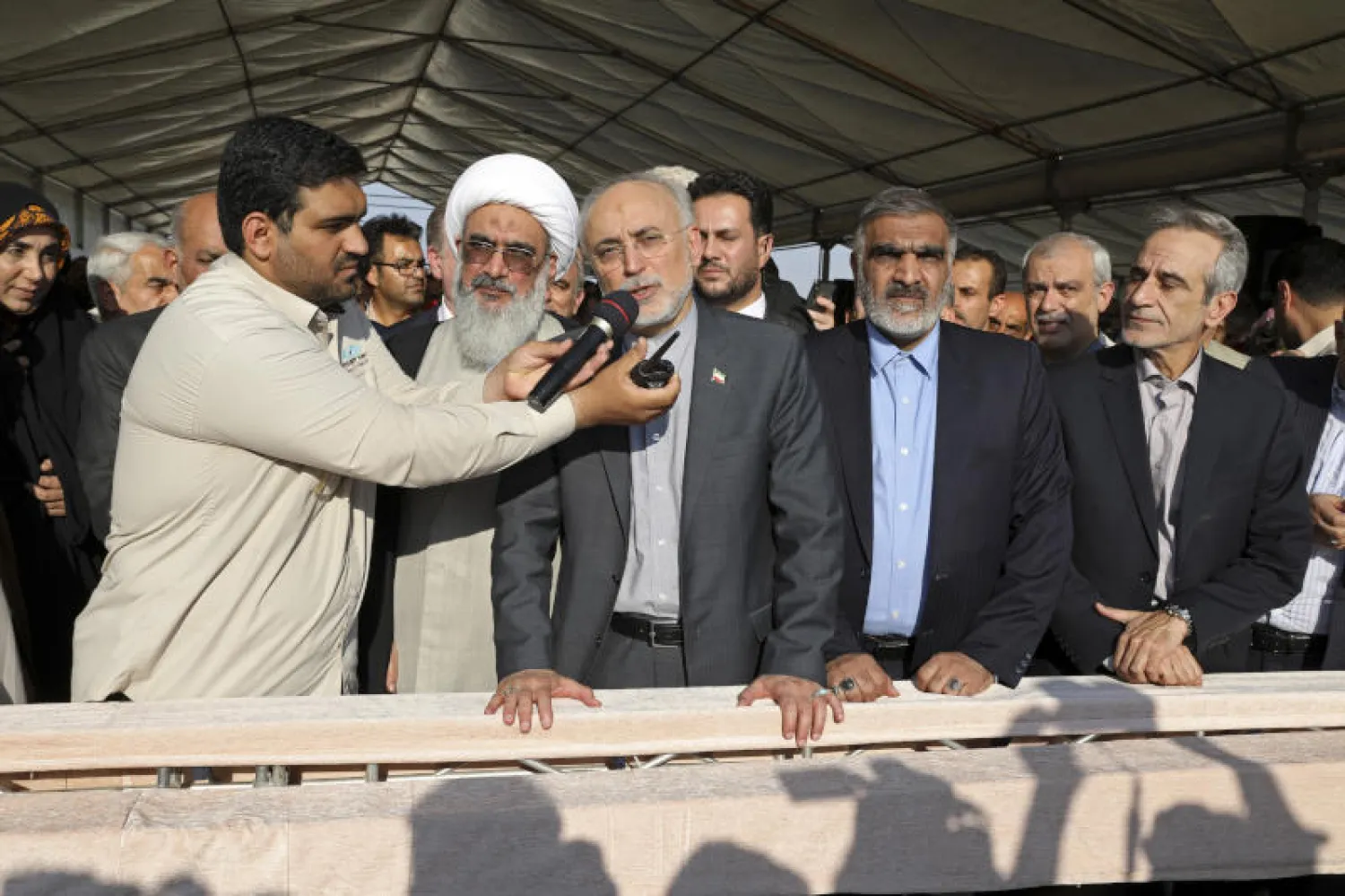 رئيس منظمة الطاقة الذرية الإيرانية علي أكبر صالحي يعطي الأوامر بصب الخرسانة لأساس مفاعل نووي ثانٍ في منشأة بوشهر (أ.ب)