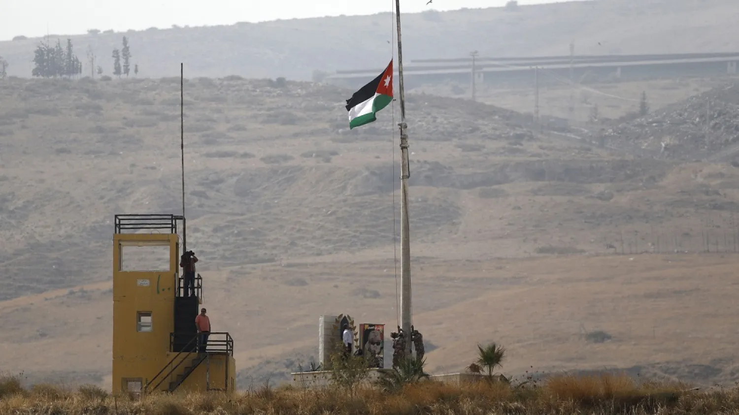 A picture taken from the Israeli side of the border fence in Naharayim, also known as Baqura, shows a Jordanian flag being raised on a military outpost in the Jordan Valley, Oct. 22, 2018. (Getty Images)