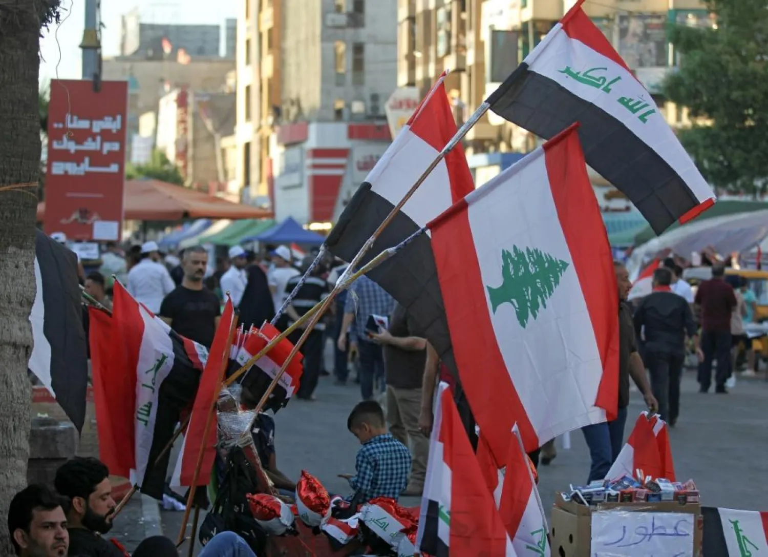 A Baghdad street vendor sells flags of Iraq and Lebanon, both gripped by anti-government protests. (AFP)