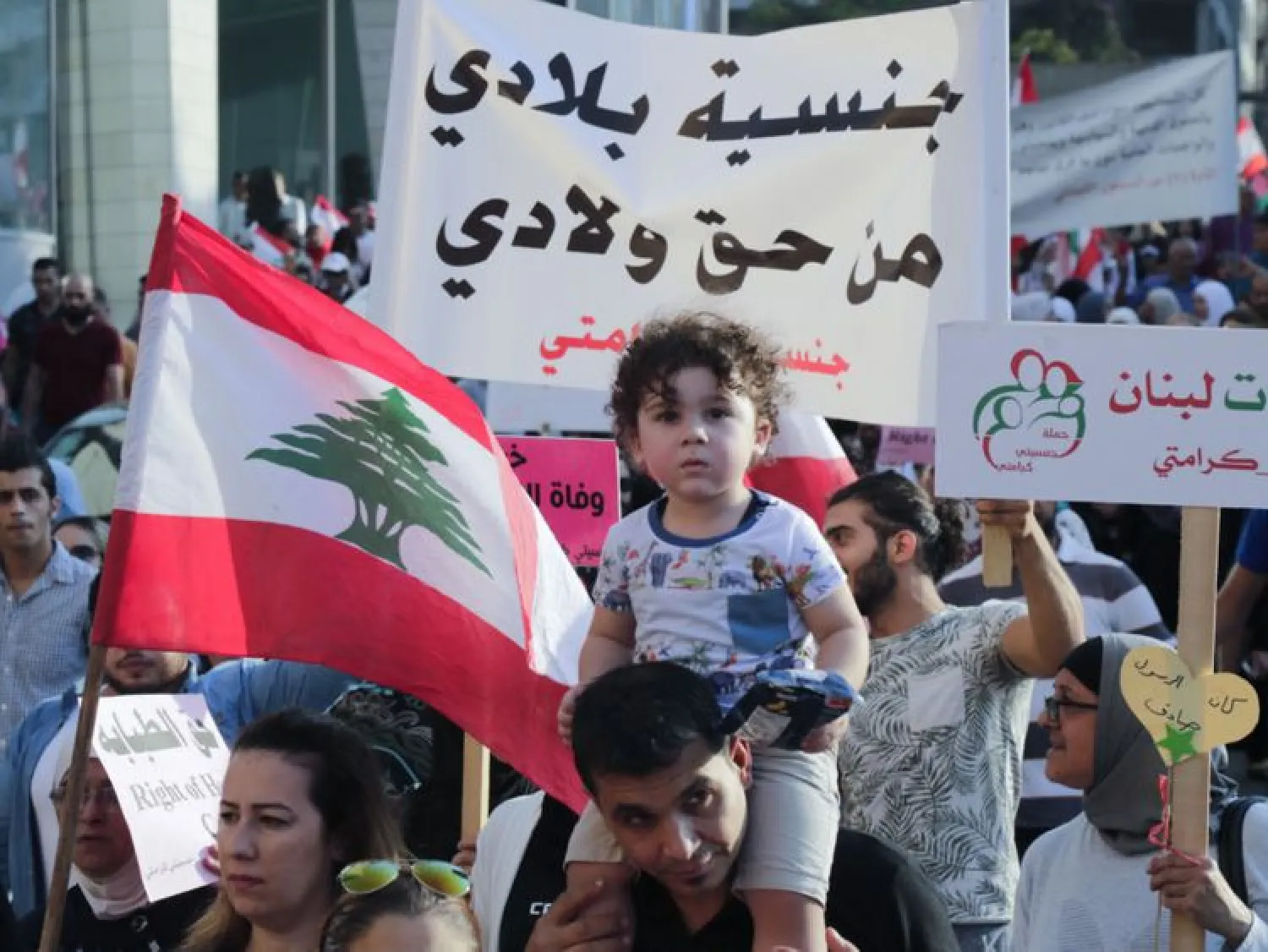 Lebanese demonstrators take part in a march in Beirut on November 10, 2019, calling for giving Lebanese women the right to transfer the nationality to their children. (AFP)