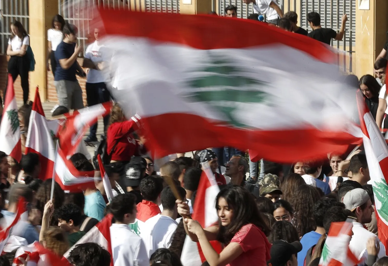 A student protester waves her national flag during protest against the government in front of the education ministry in Beirut, Lebanon, Friday, Nov. 8, 2019. (AP)