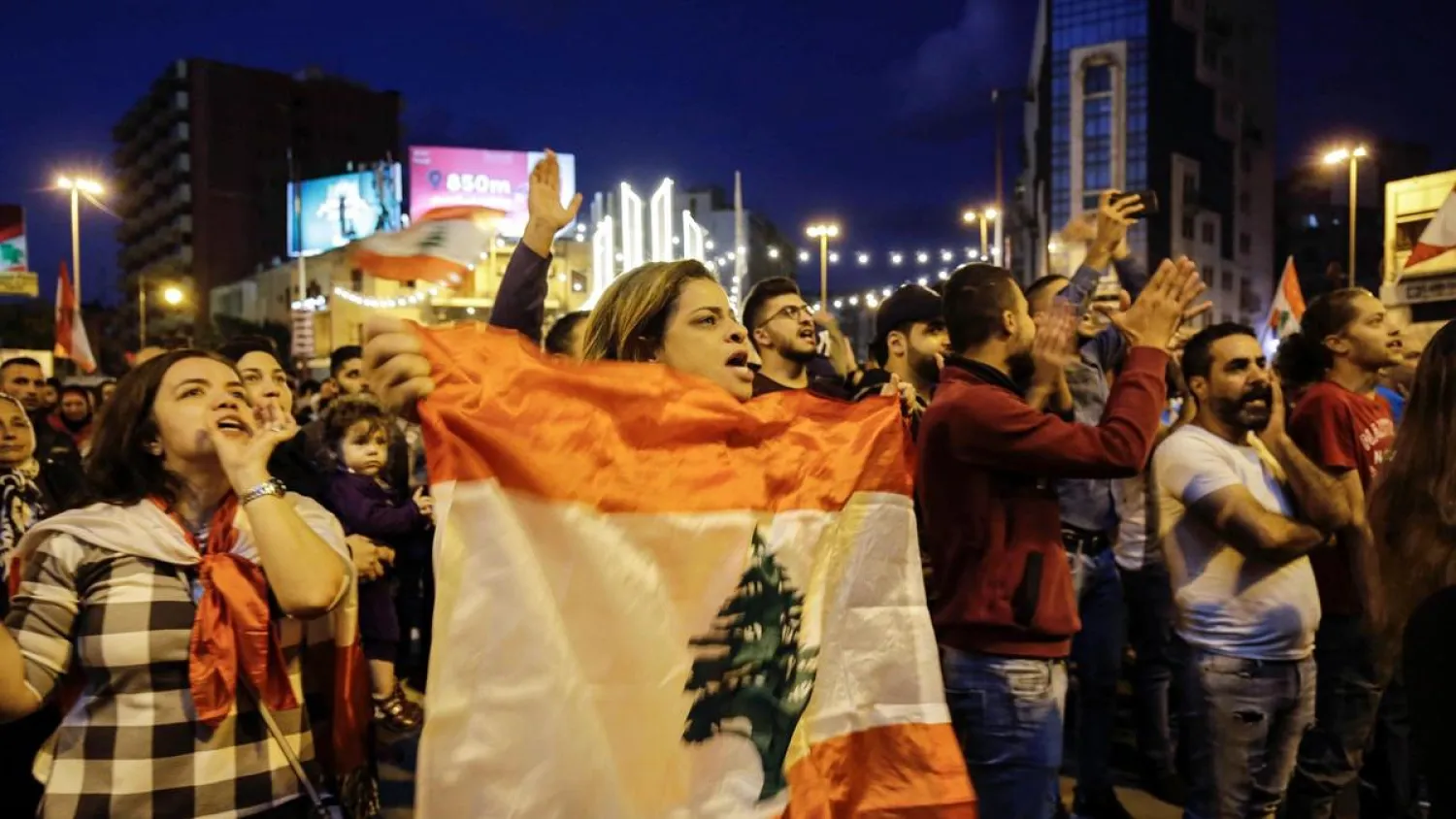 Lebanese anti-government demonstrators wave flags and shout slogans during a demonstration in Tripoli's al-Nour Square. (AFP)
