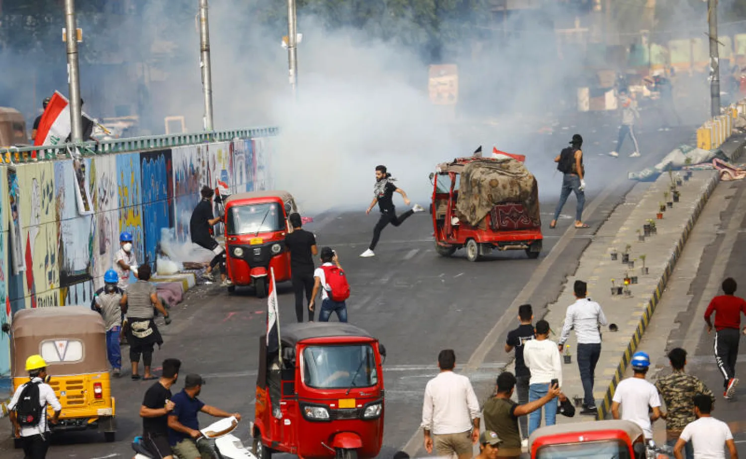 - متظاهرون يستخدمون التوك توك خلال الاحتجاجات المستمرة المناهضة للحكومة في بغداد (رويترز)
- متظاهر عراقي وهو يسير أمام قوات الأمن خلال الاحتجاجات (رويترز)
- متظاهرون عراقيون يحملون رجلاً مصاباً (رويترز)