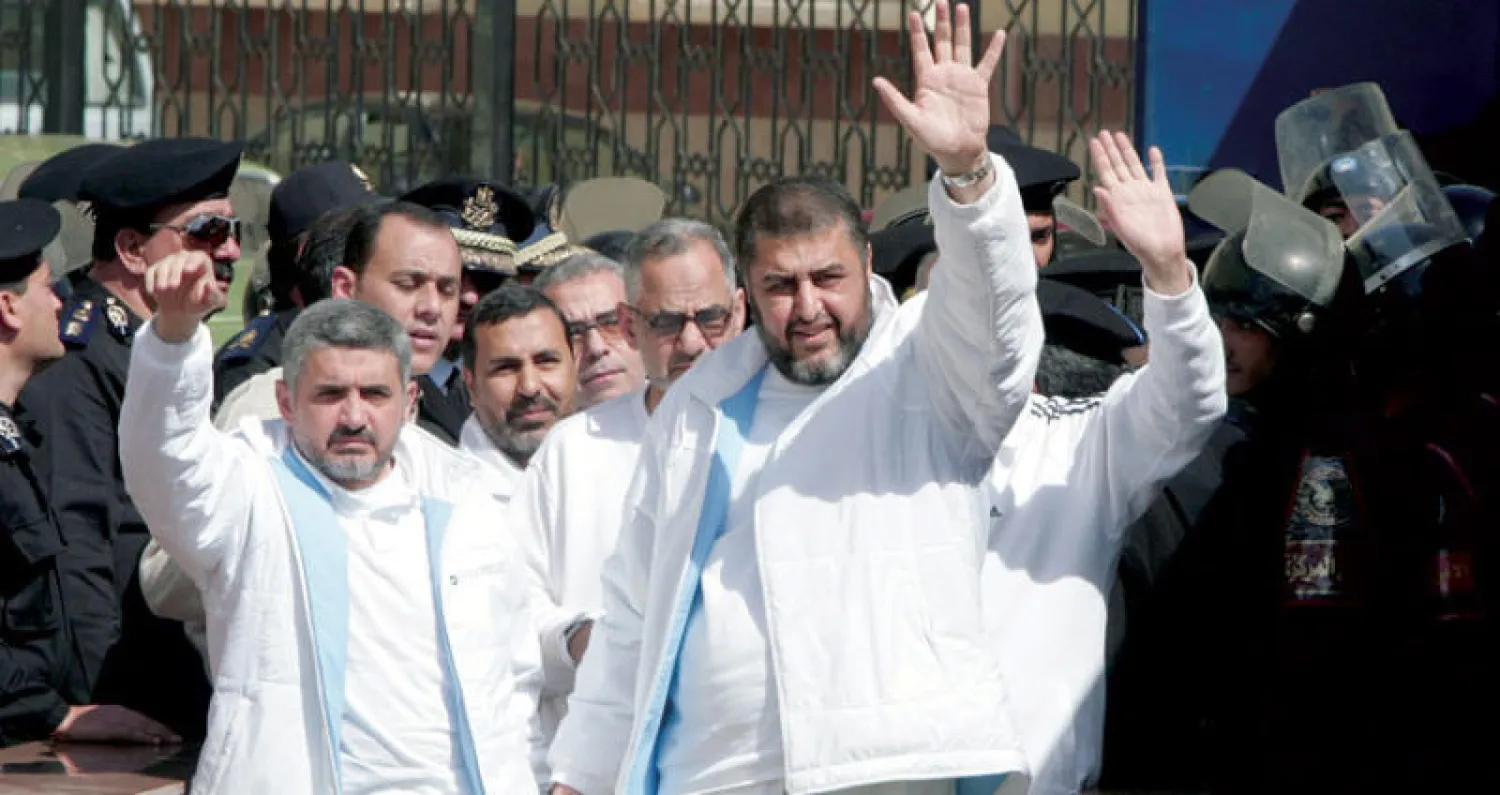 خيرت الشاطر وحسن مالك في طريقهما إلى إحدى جلسات محاكمة قادة «الإخوان» في 2007 (غيتي)