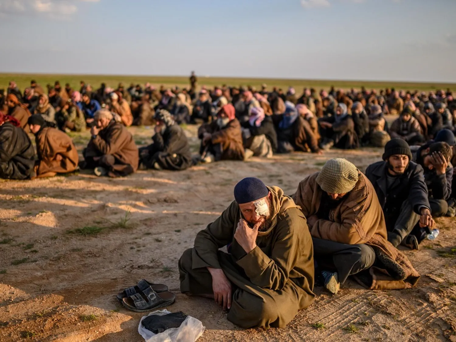 Men suspected of being ISIS fighters wait to be searched by the Kurdish-led Syrian Democratic Forces. (AFP)