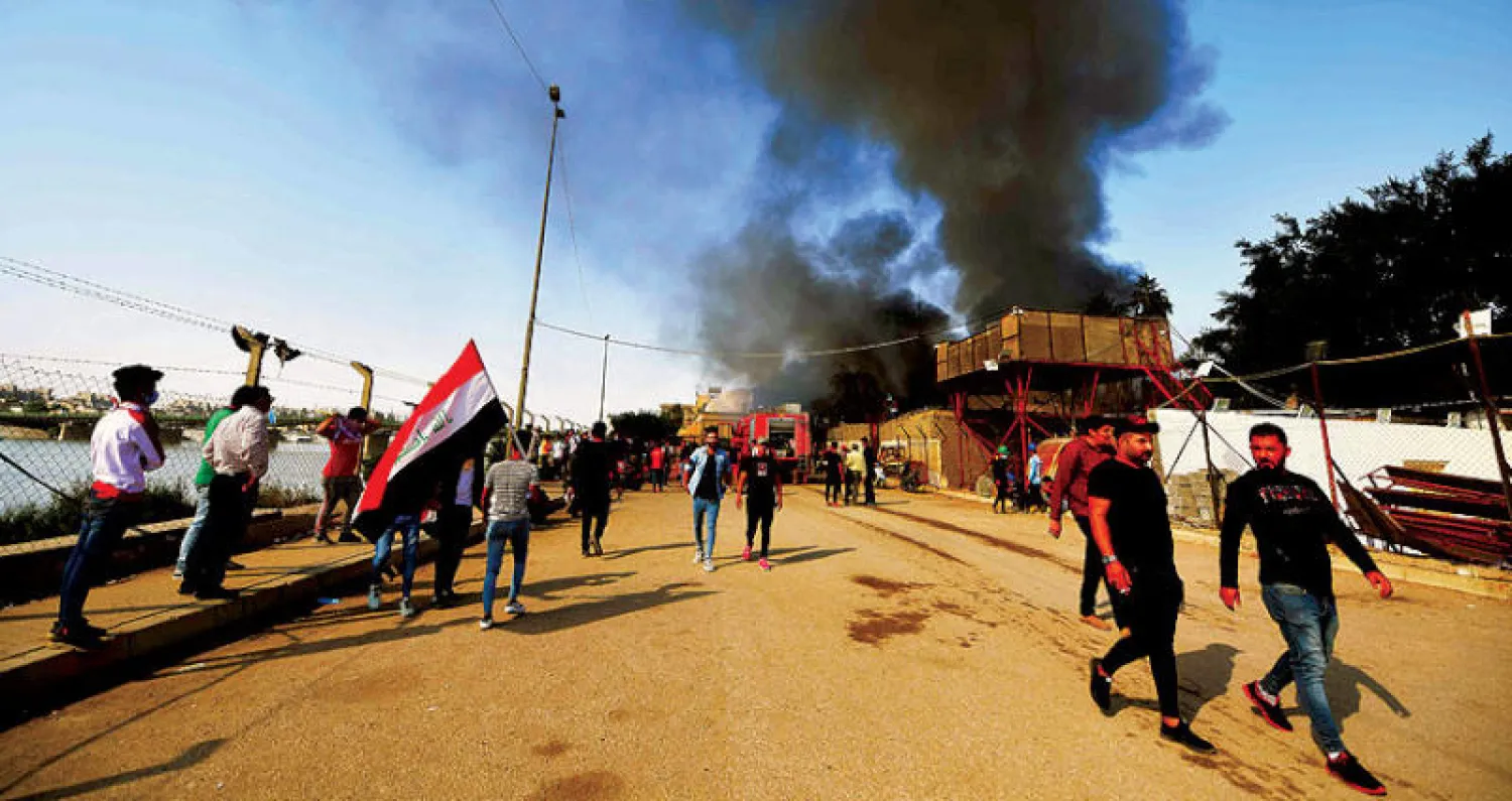 الدخان يتصاعد من مبنى قرب ساحة الخلاني وسط بغداد خلال مواجهات بين محتجين وقوات الأمن أمس (إ.ب.أ)