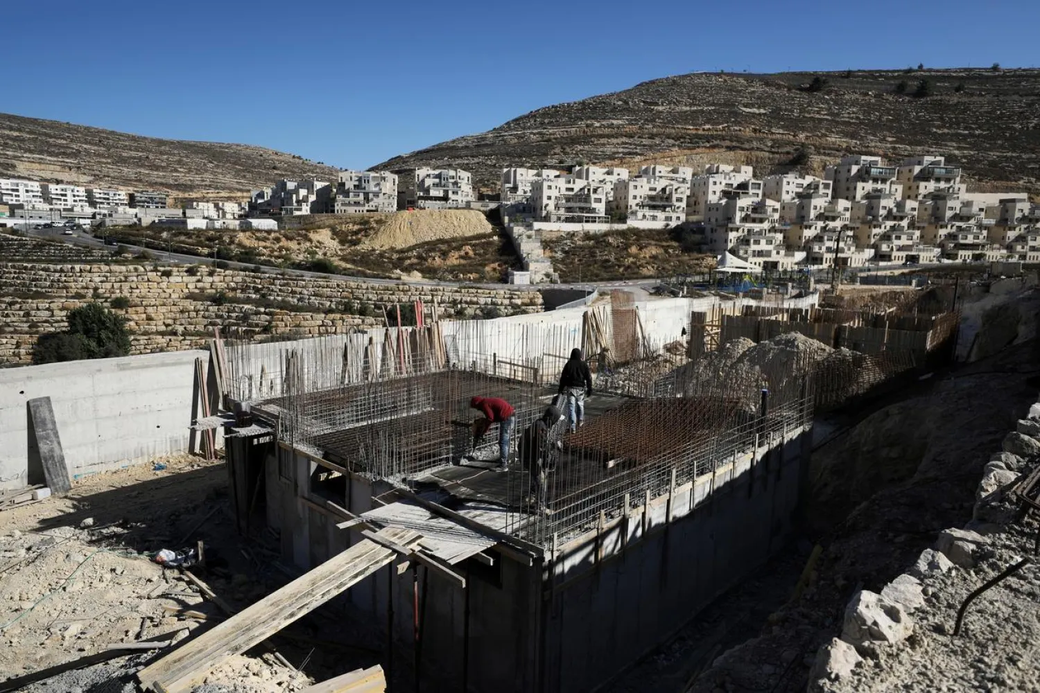 Laborers work in a construction site in the Israeli settlement of Ramat Givat Zeev in the occupied-West Bank November 19, 2019. (Reuters)