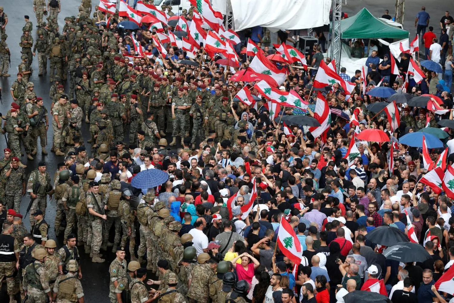 Lebanese army soldiers stand guard next to demonstrators during ongoing anti-government protests at a highway in Jal el-Dib, Lebanon October 23, 2019. REUTERS/Mohamed Azakir