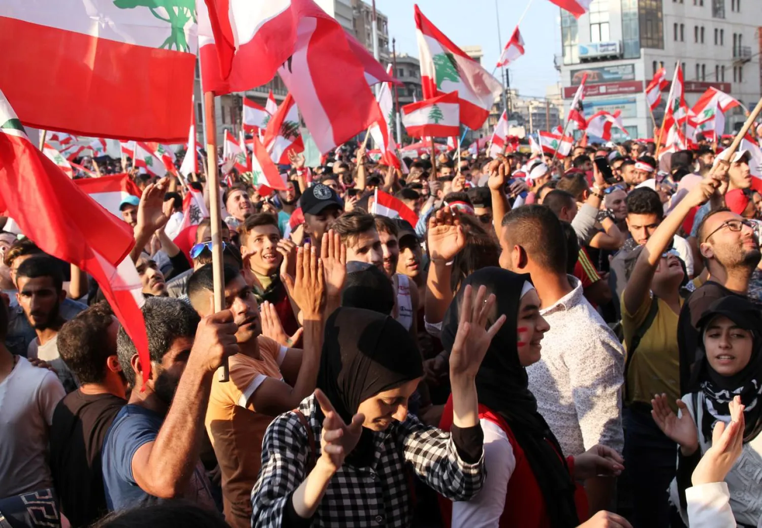 Demonstrators carry national flags during an anti-government protest in Tripoli, Lebanon October 21, 2019. REUTERS/Omar Ibrahim
